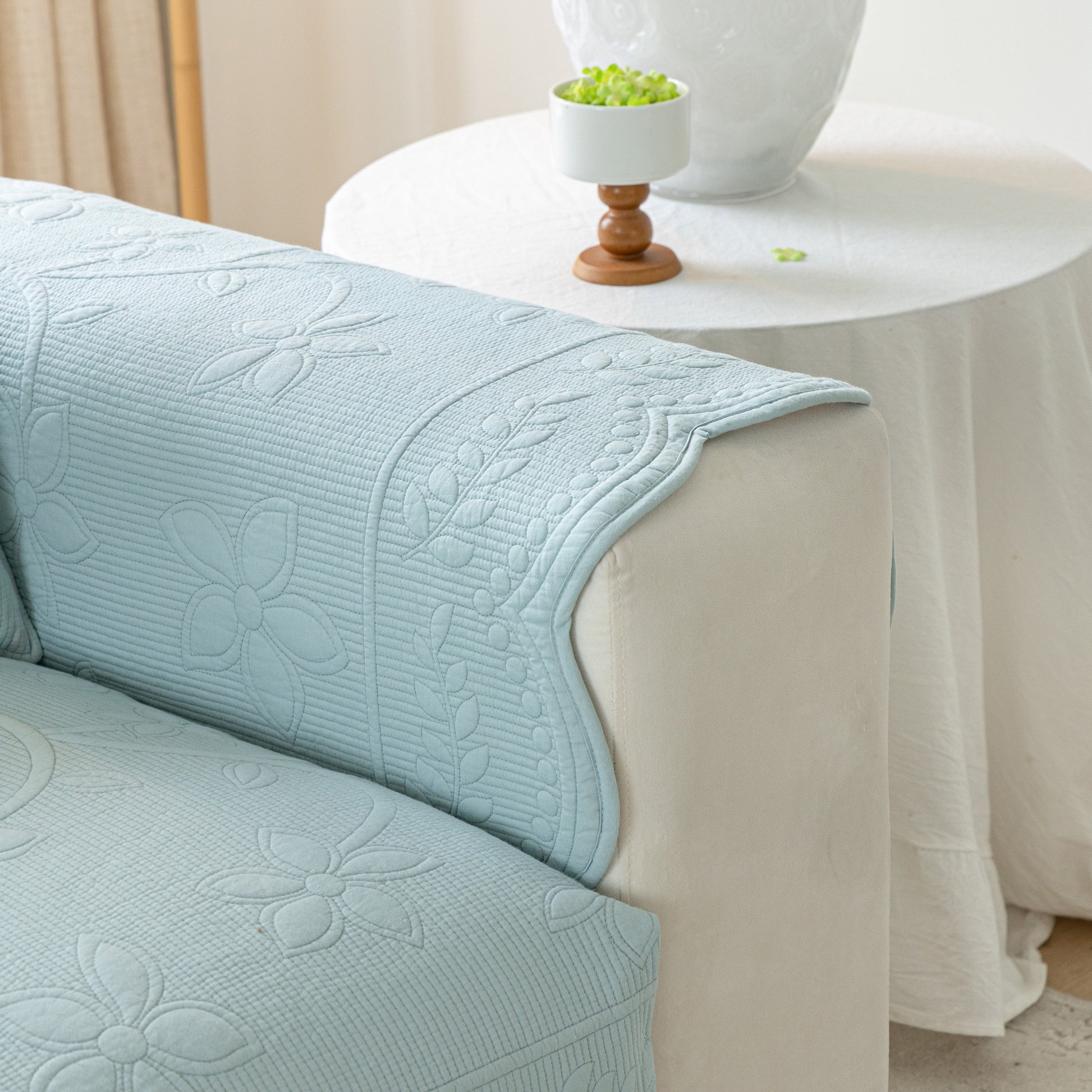 Floral Cotton Quilted Sofa Cover, Non-Slip Couch Protector with Scalloped Edges in a living room setting