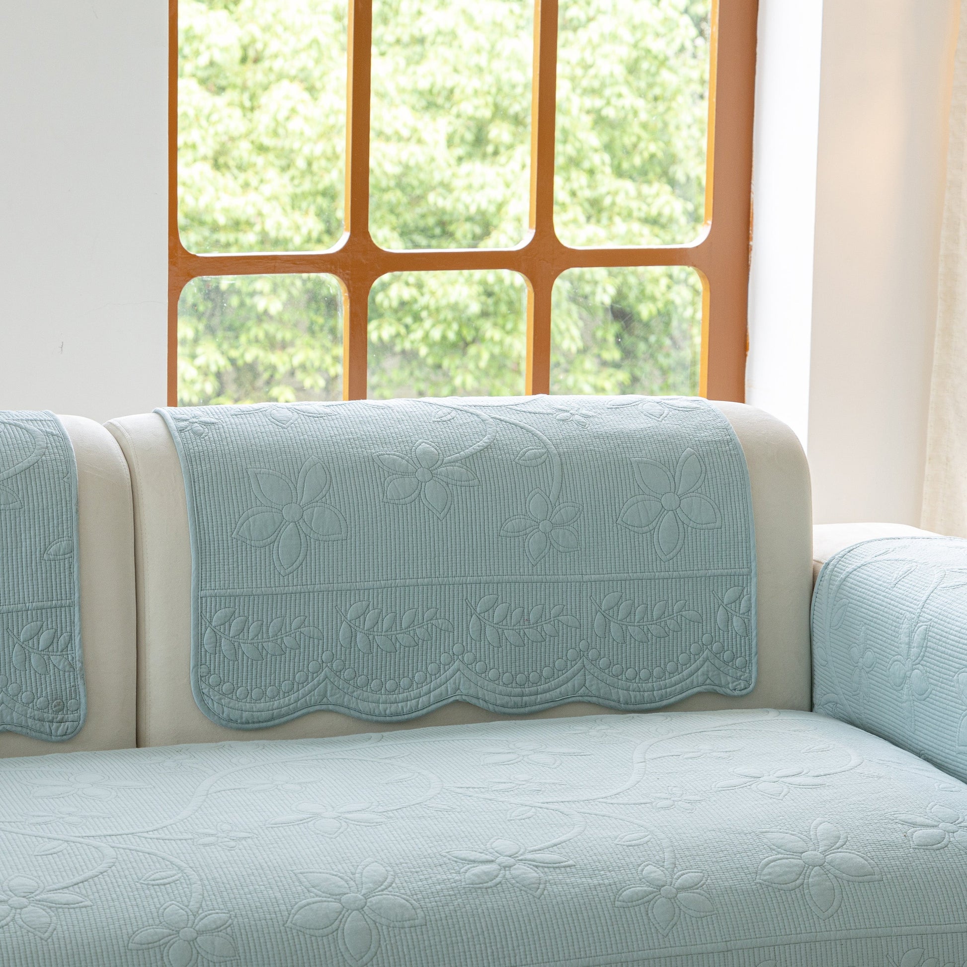Floral Cotton Quilted Sofa Cover, Non-Slip Couch Protector with Scalloped Edges in a cozy living room setting.