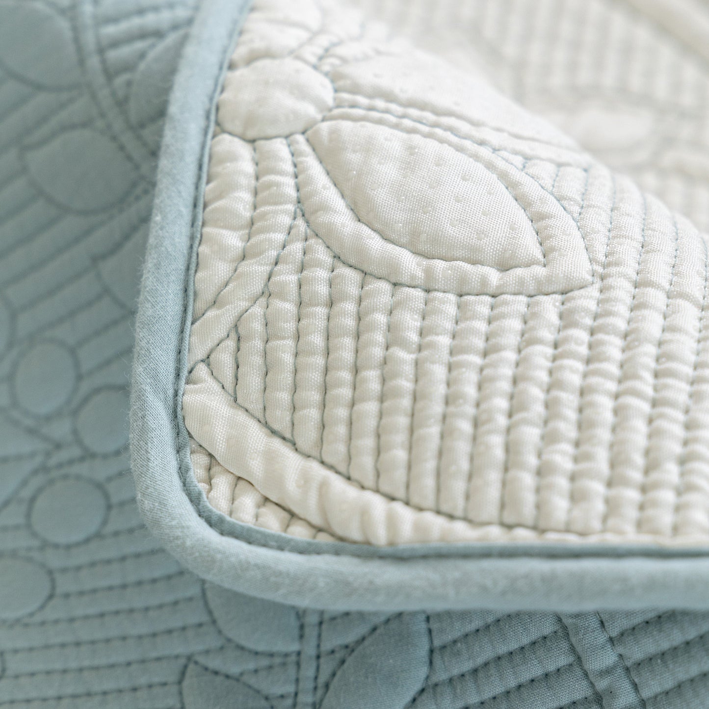 Close-up of Floral Cotton Quilted Sofa Cover, Non-Slip Couch Protector with Scalloped Edges, showing embroidery detail.