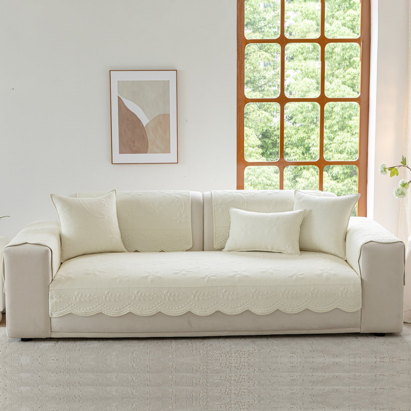 Floral Cotton Quilted Sofa Cover, Non-Slip Couch Protector with Scalloped Edges on white sofa in well-lit living room
