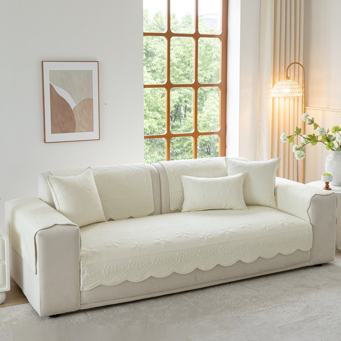 Floral Cotton Quilted Sofa Cover, Non-Slip Couch Protector with Scalloped Edges on a cozy white sofa in a bright living room.