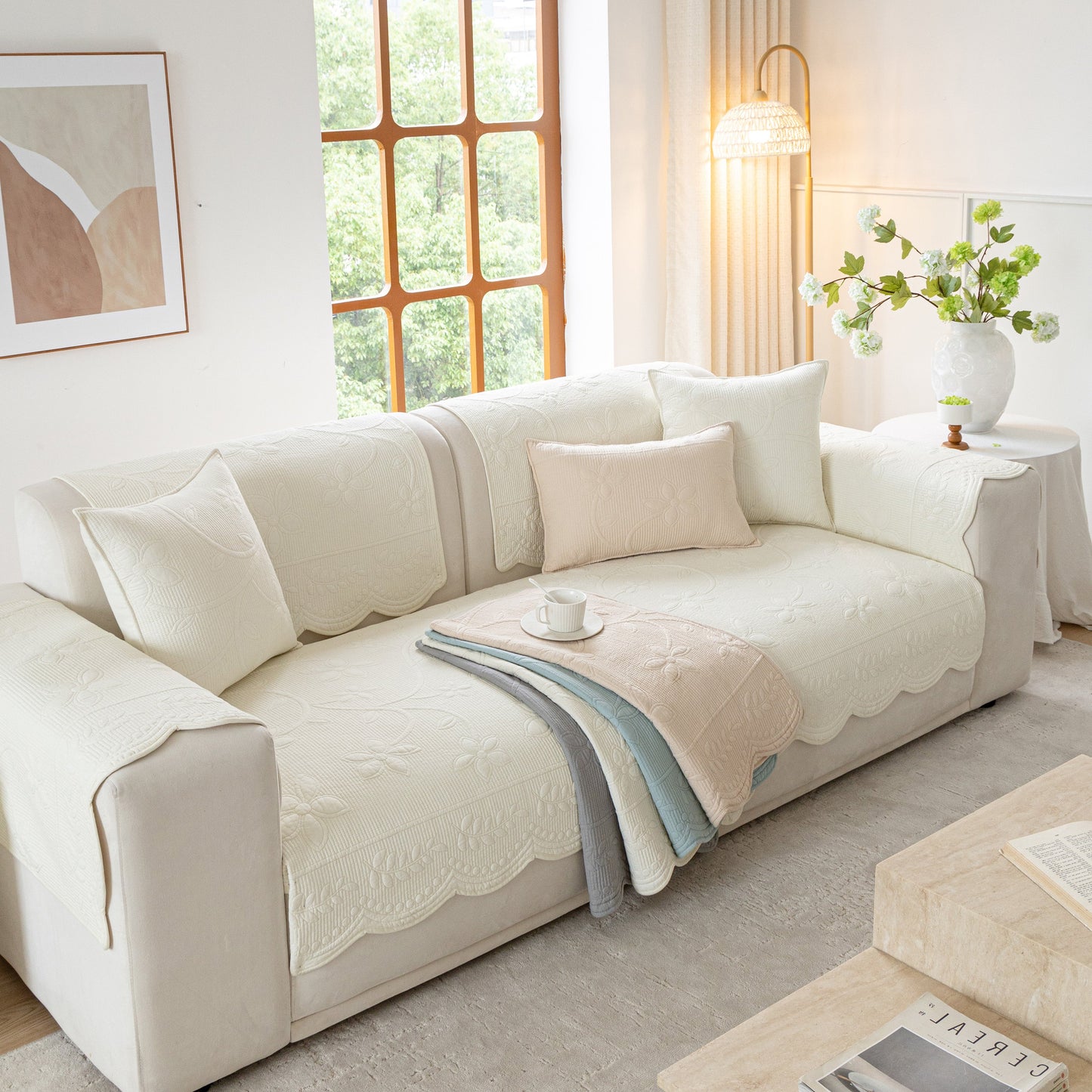 Floral Cotton Quilted Sofa Cover, Non-Slip Couch Protector with Scalloped Edges on beige couch in a bright living room