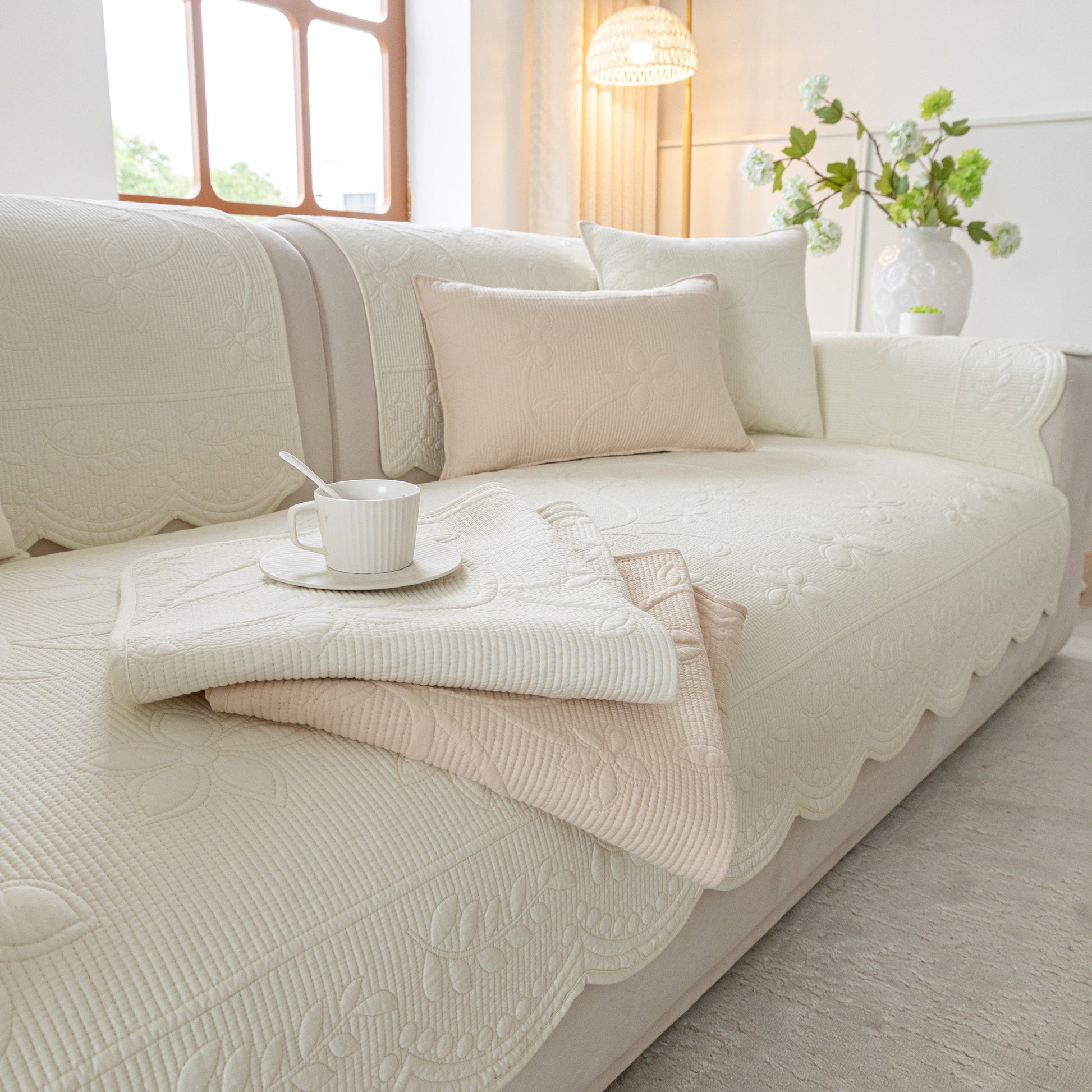 Floral Cotton Quilted Sofa Cover, Non-Slip Couch Protector with Scalloped Edges in a cozy living room setting.