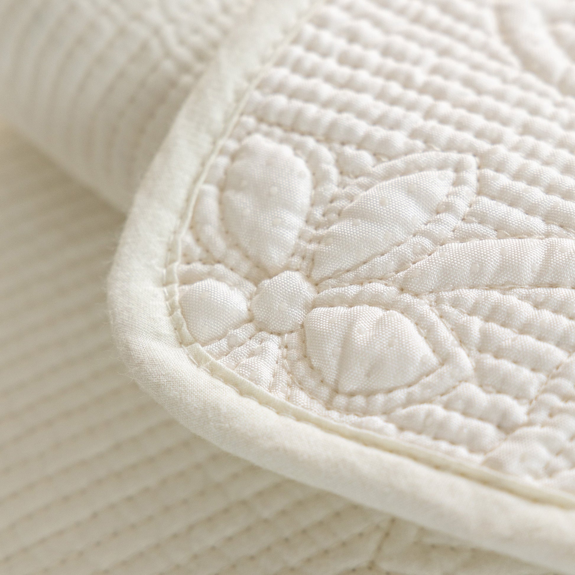 Close-up of floral embroidery on Floral Cotton Quilted Sofa Cover, Non-Slip Couch Protector with Scalloped Edges