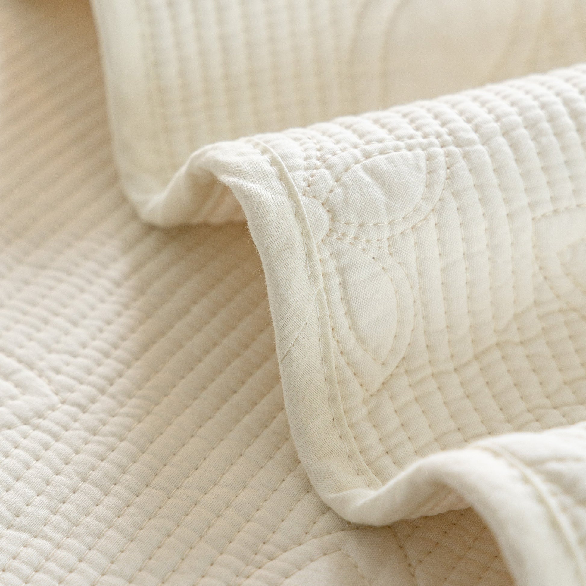 Close-up of Floral Cotton Quilted Sofa Cover, Non-Slip Couch Protector with Scalloped Edges, showing embroidery details.