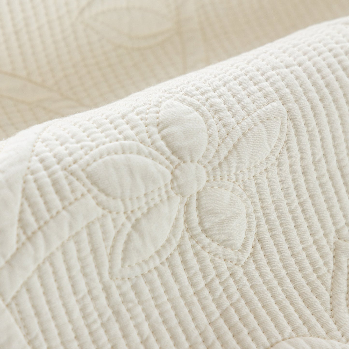 Close-up of Floral Cotton Quilted Sofa Cover, Non-Slip Couch Protector with Scalloped Edges showing elegant embroidered floral pattern.