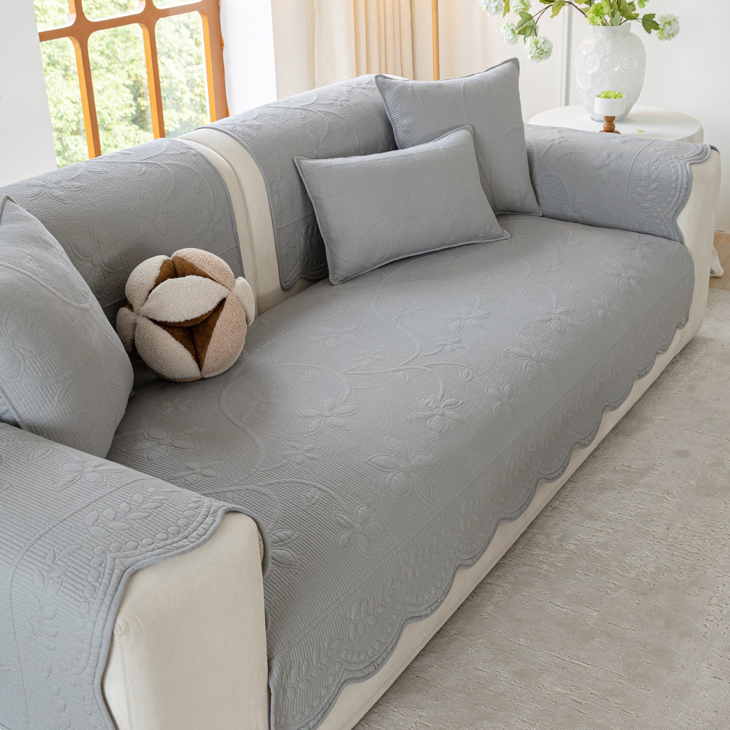 Floral Cotton Quilted Sofa Cover, Non-Slip Couch Protector with Scalloped Edges on a modern sofa