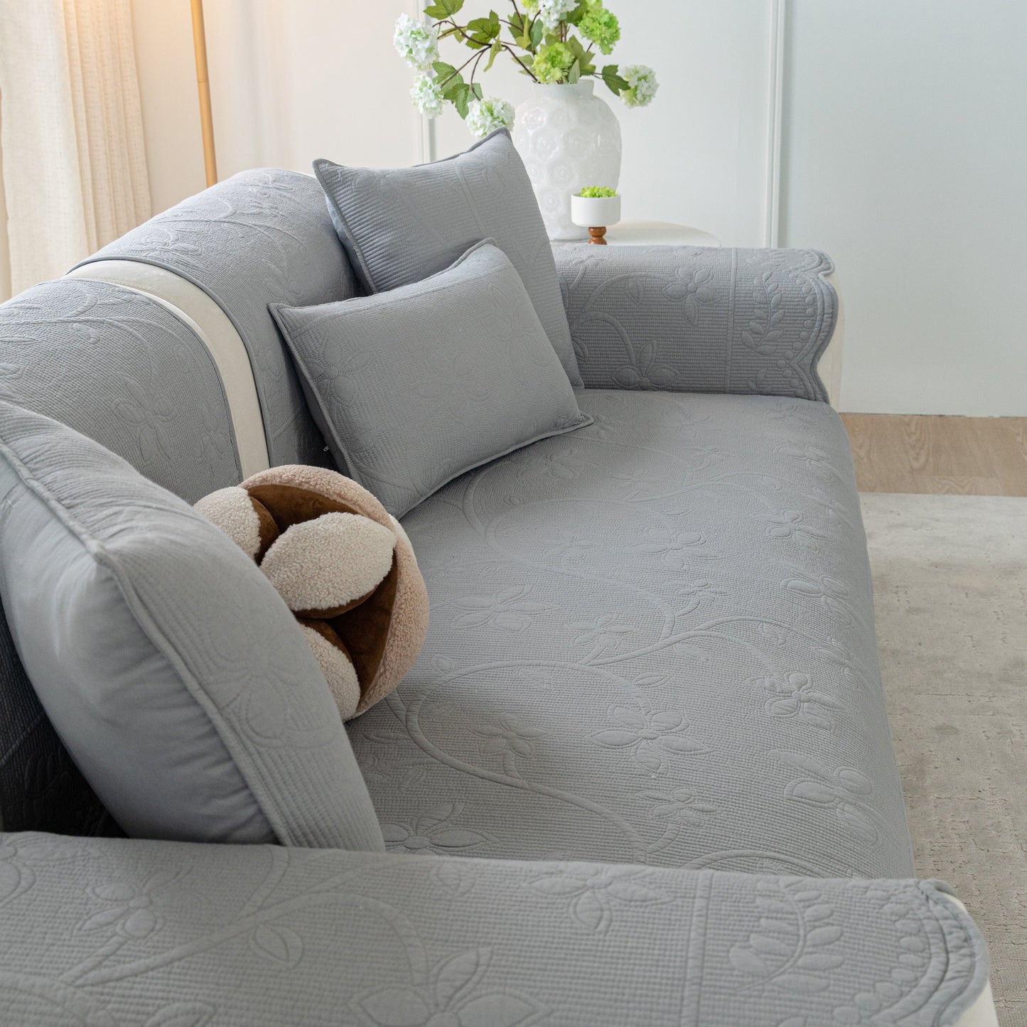Floral Cotton Quilted Sofa Cover, Non-Slip Couch Protector with Scalloped Edges in a cozy living room setting.