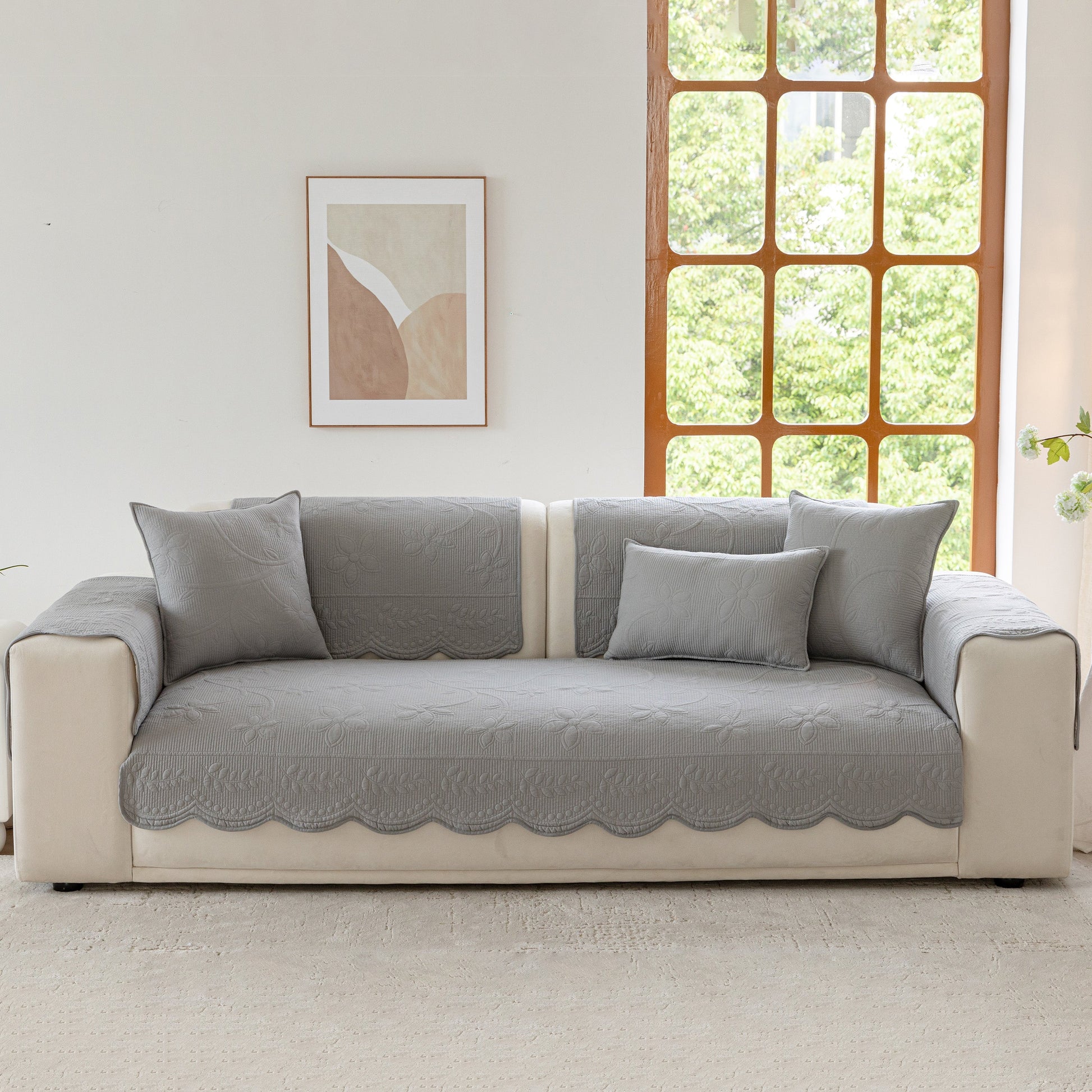 Floral Cotton Quilted Sofa Cover, Non-Slip Couch Protector with Scalloped Edges displayed on a sofa.