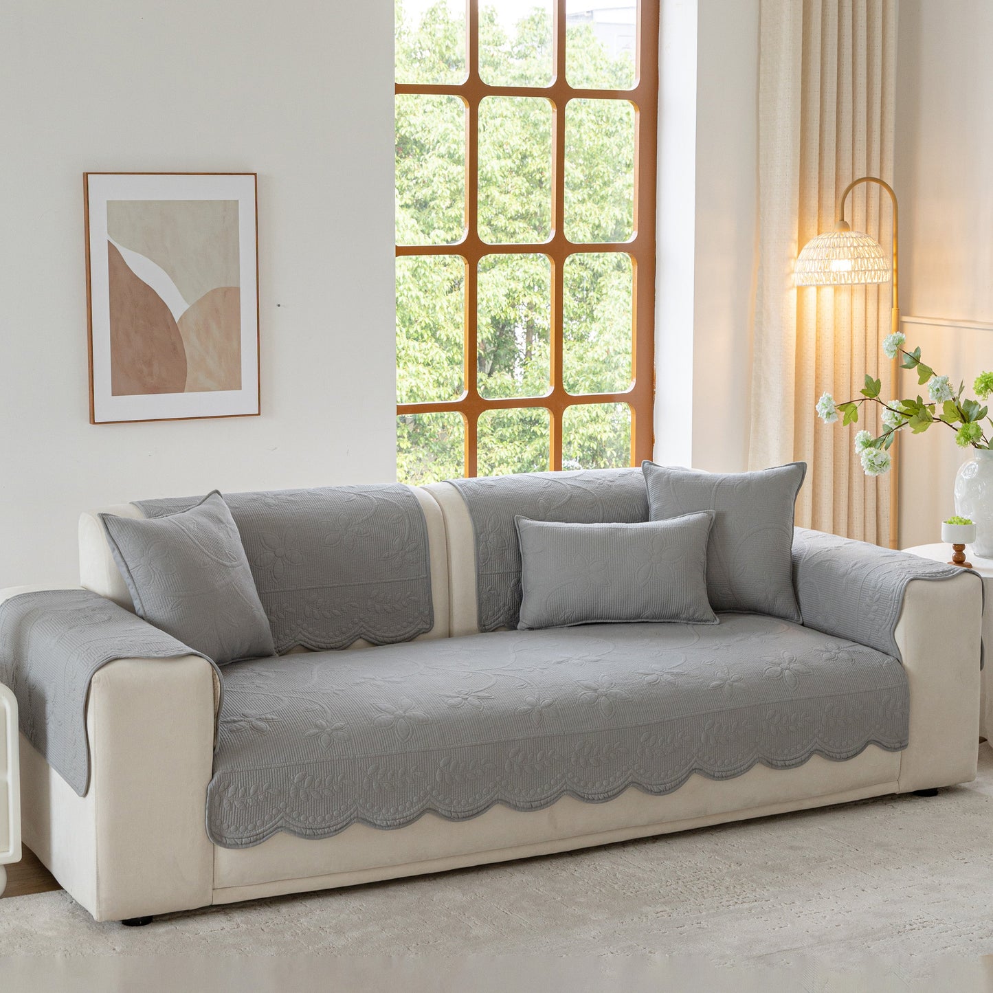 Floral Cotton Quilted Sofa Cover, Non-Slip Couch Protector with Scalloped Edges on a beige sofa in a cozy living room.