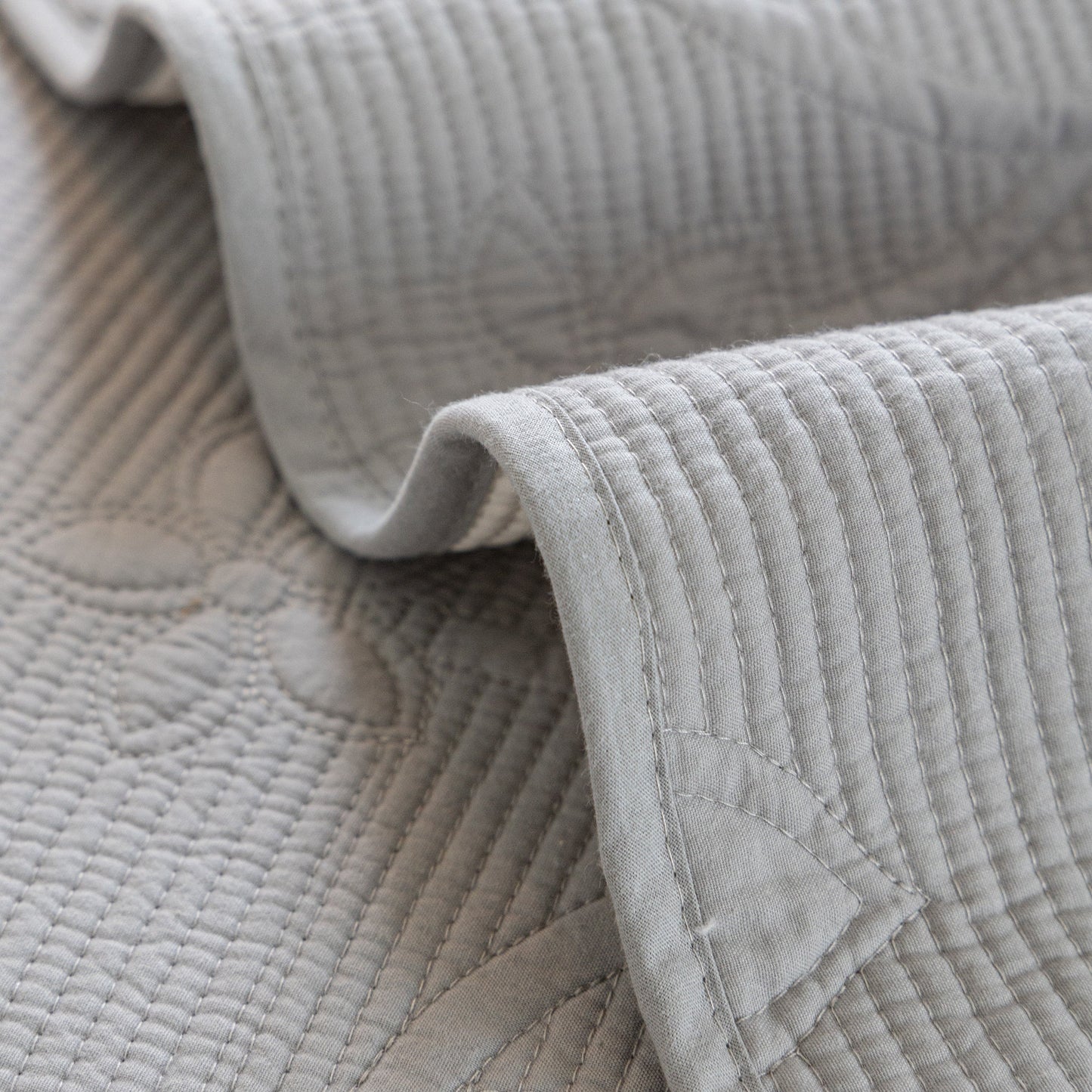Close-up of Floral Cotton Quilted Sofa Cover, Non-Slip Couch Protector with Scalloped Edges showing embroidery detail.