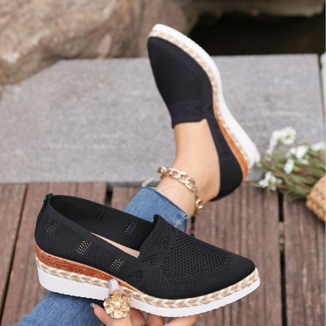 Black slip-on flats with woven hemp-rope platform and pointed toe for a stylish look outdoors.