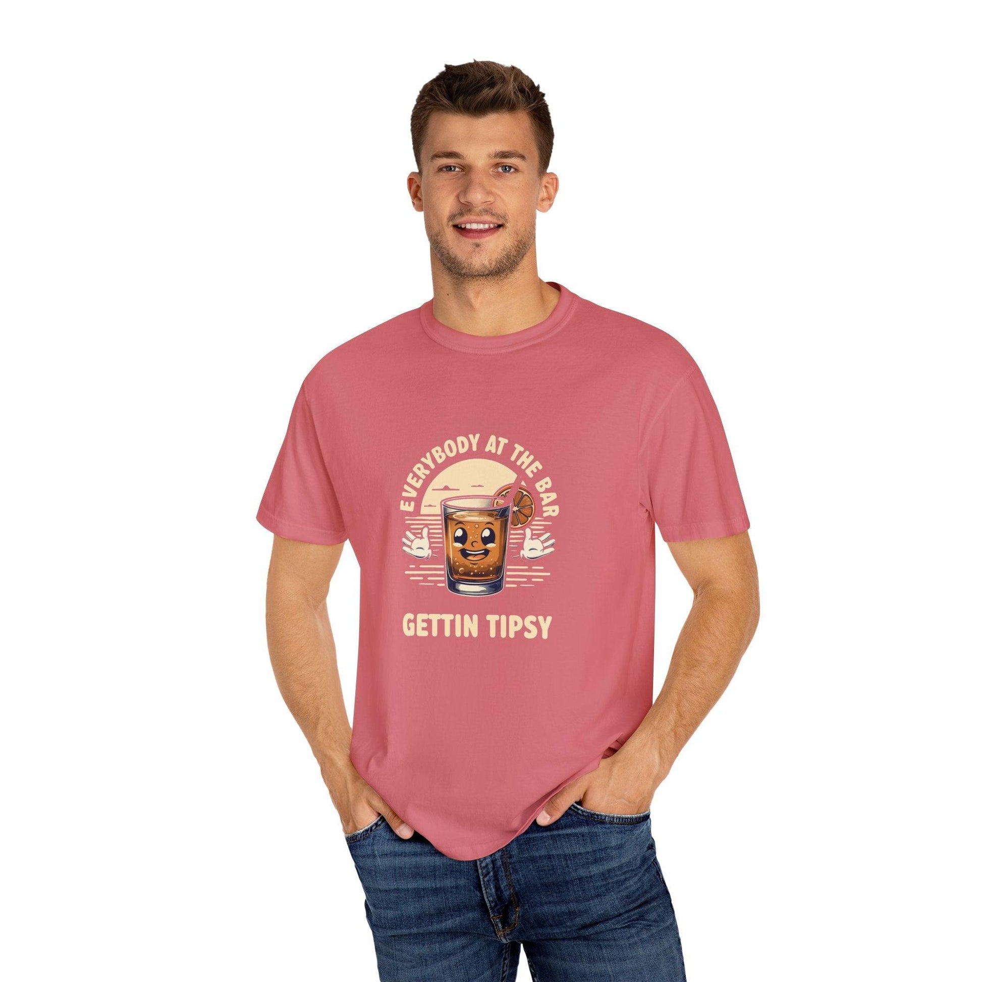 Man wearing 'Everybody at the Bar Gettin Tipsy' unisex garment-dyed t-shirt with whiskey glass graphic.