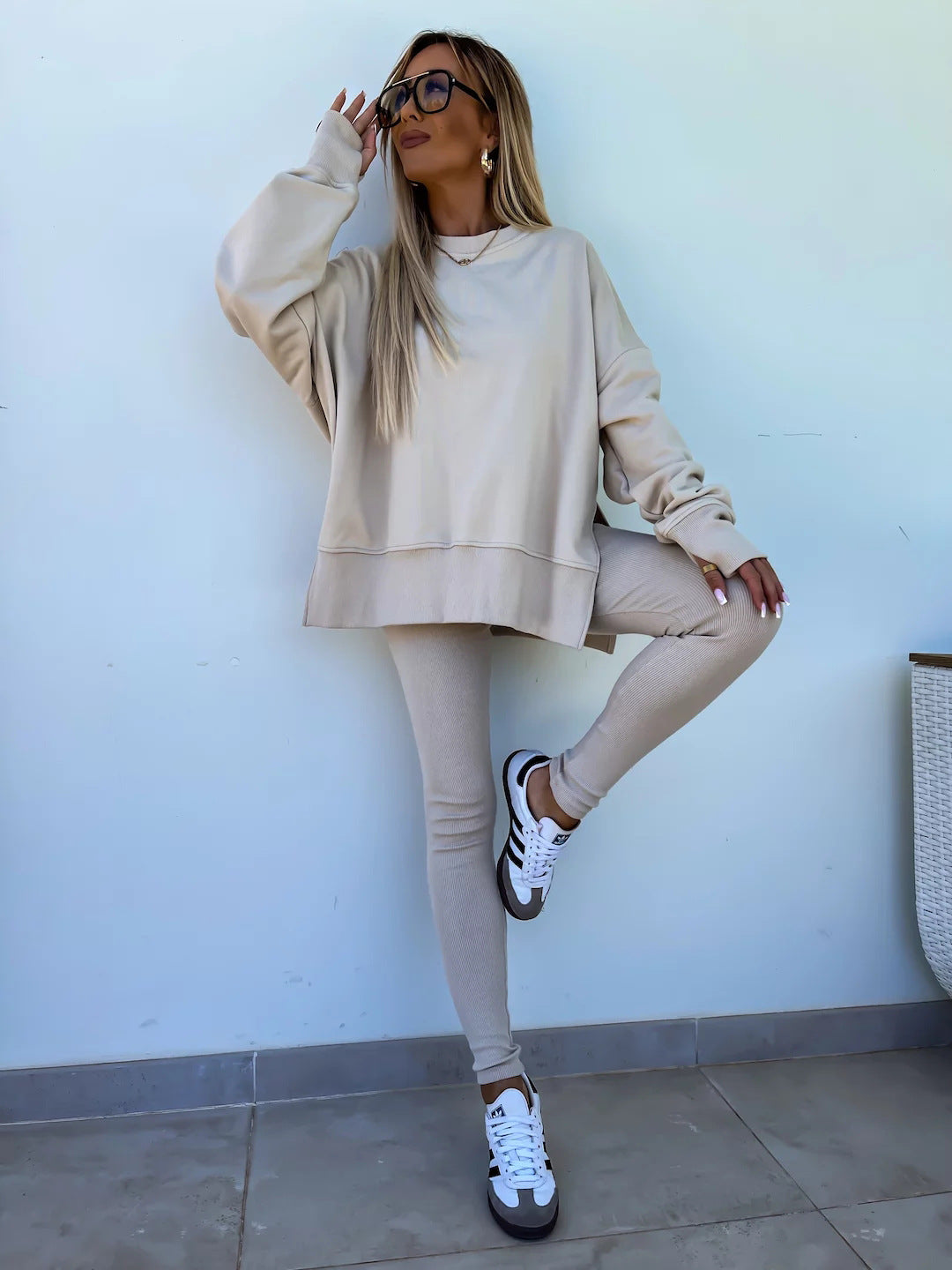 Woman wearing Women’s Casual Sweater Suit – Loose Split Top & Fitted Trousers Set in beige with casual sneakers.