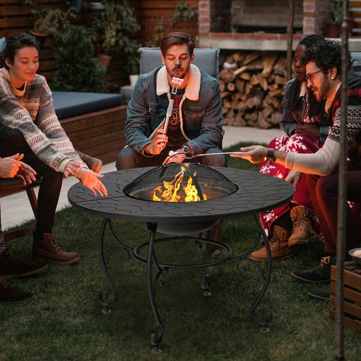 Friends enjoying a 35.5 Feet Patio Fire Pit Dining Table With Cooking BBQ Grate on a backyard lawn at night.