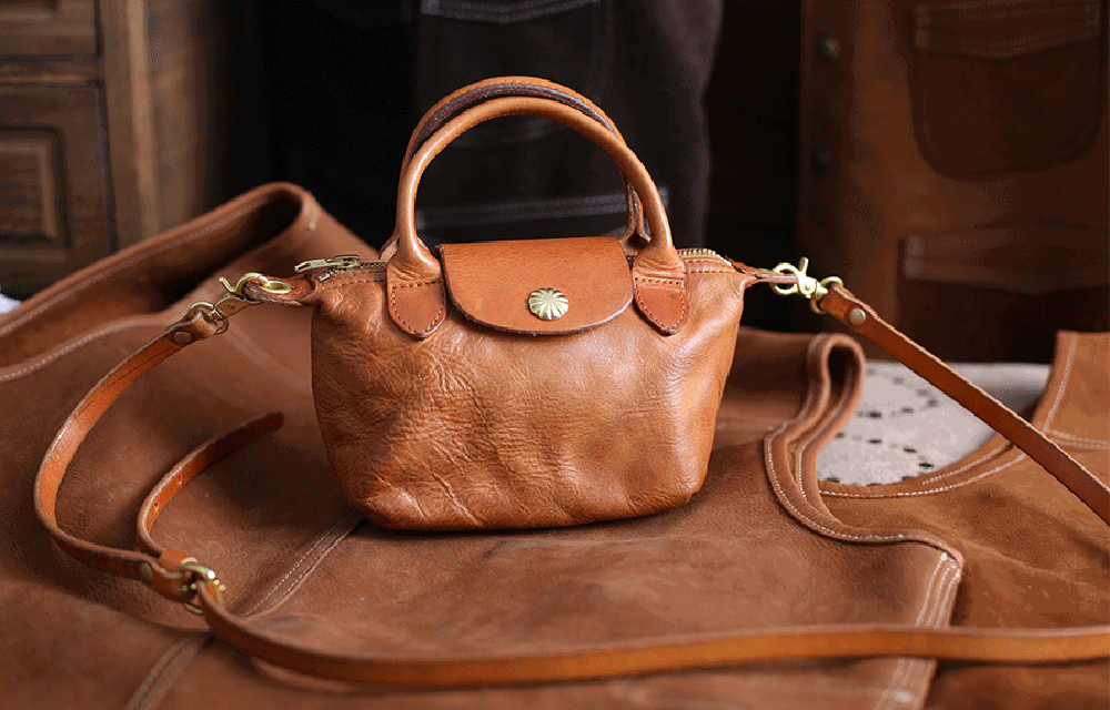 Vintage Luxe Horse Skin Leather Handbag with antique silver-tone hardware, displayed on brown fabric backdrop.