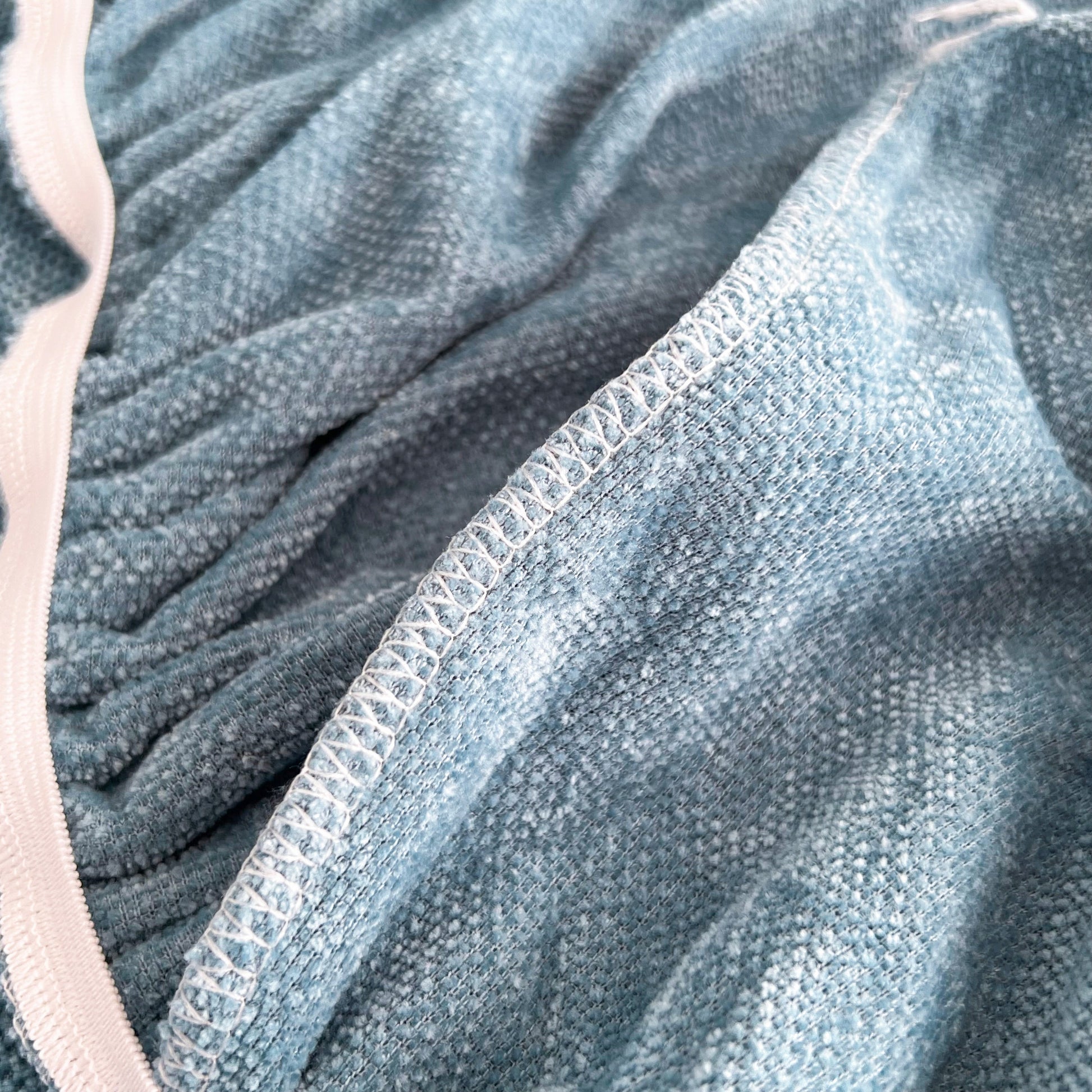Close-up of Universal Elastic Skirt Sofa Slipcover fabric showing stretchable chenille material for furniture protection and style.