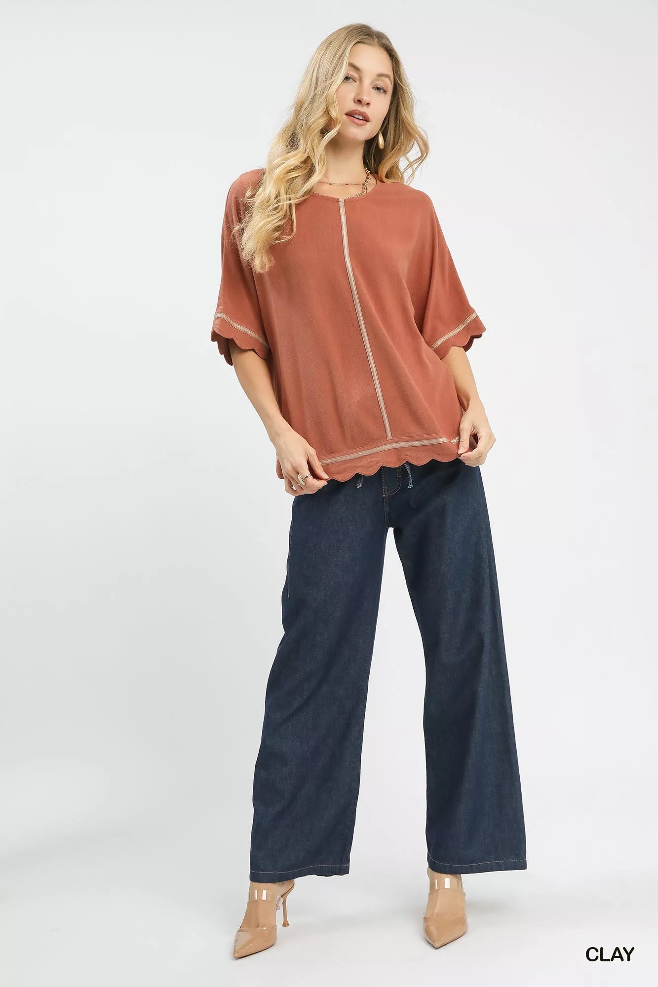 Woman wearing Umgee Linen Blend Scallop Trim Top in clay with jeans