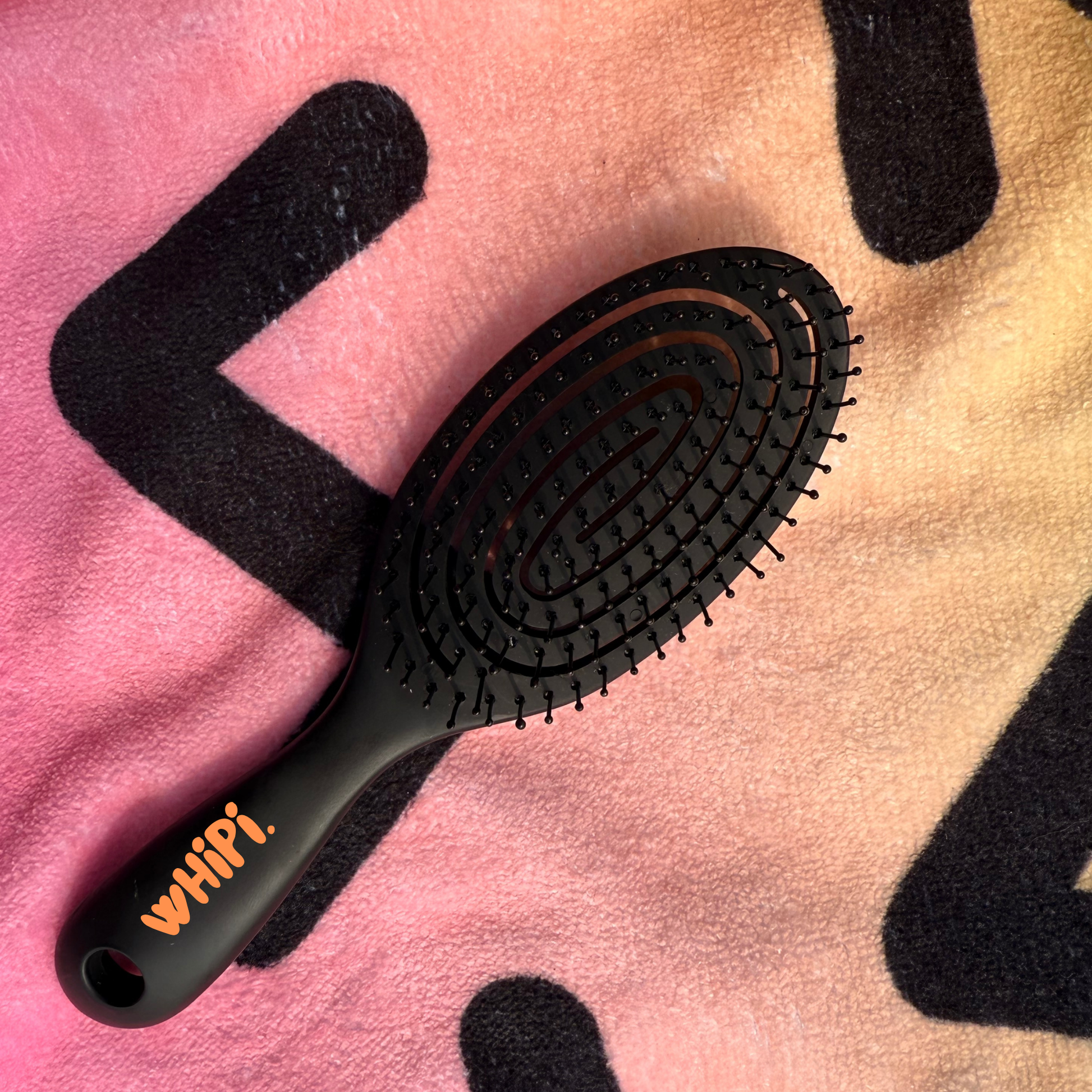 Detangle- Crown Detangle Brush  Black with soft-flex design on colorful background.
