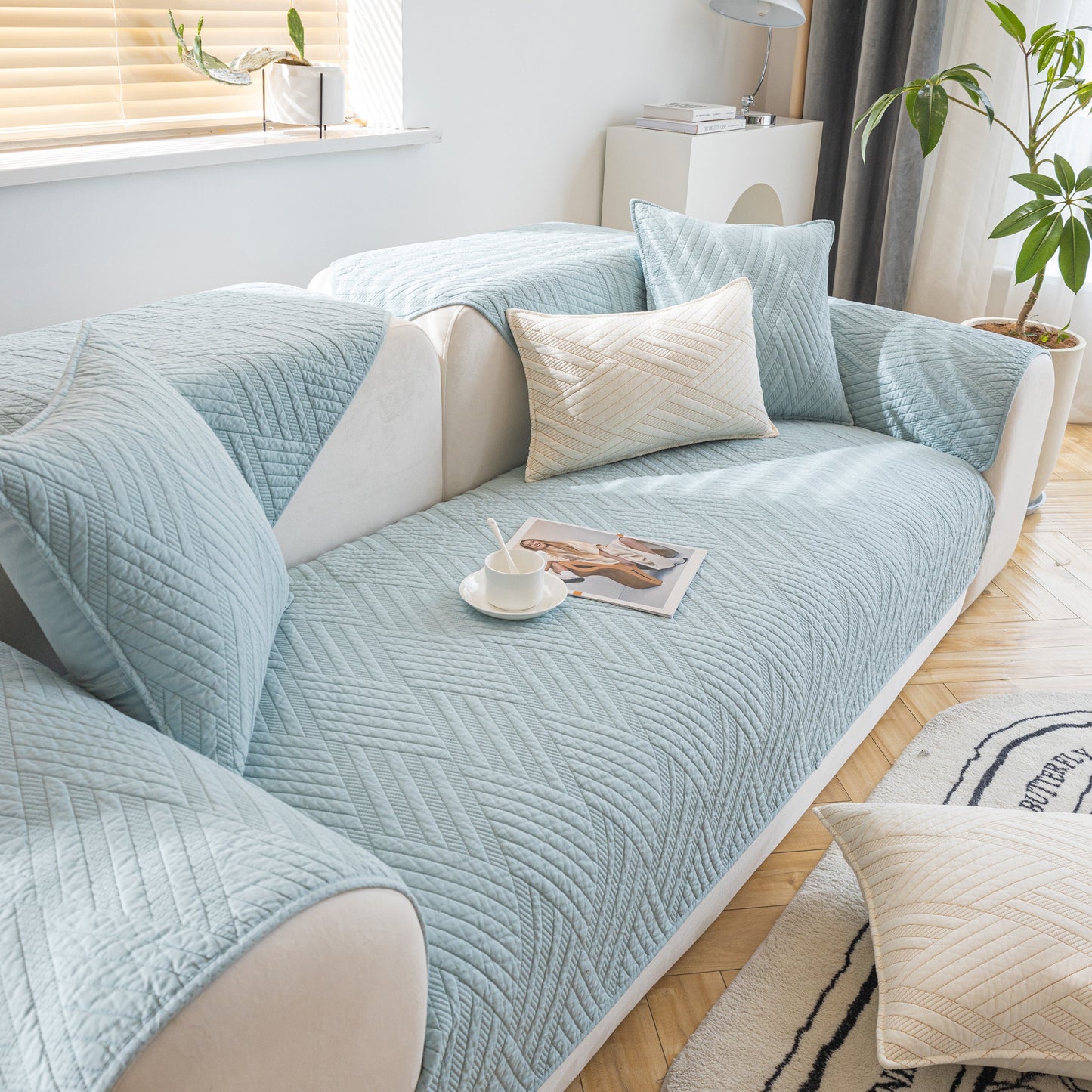 Quilted Geometric Cotton Sofa Cover, Non-Slip & Thick Padded Furniture Covers in blue, showing textured pattern and pillows on sofa.