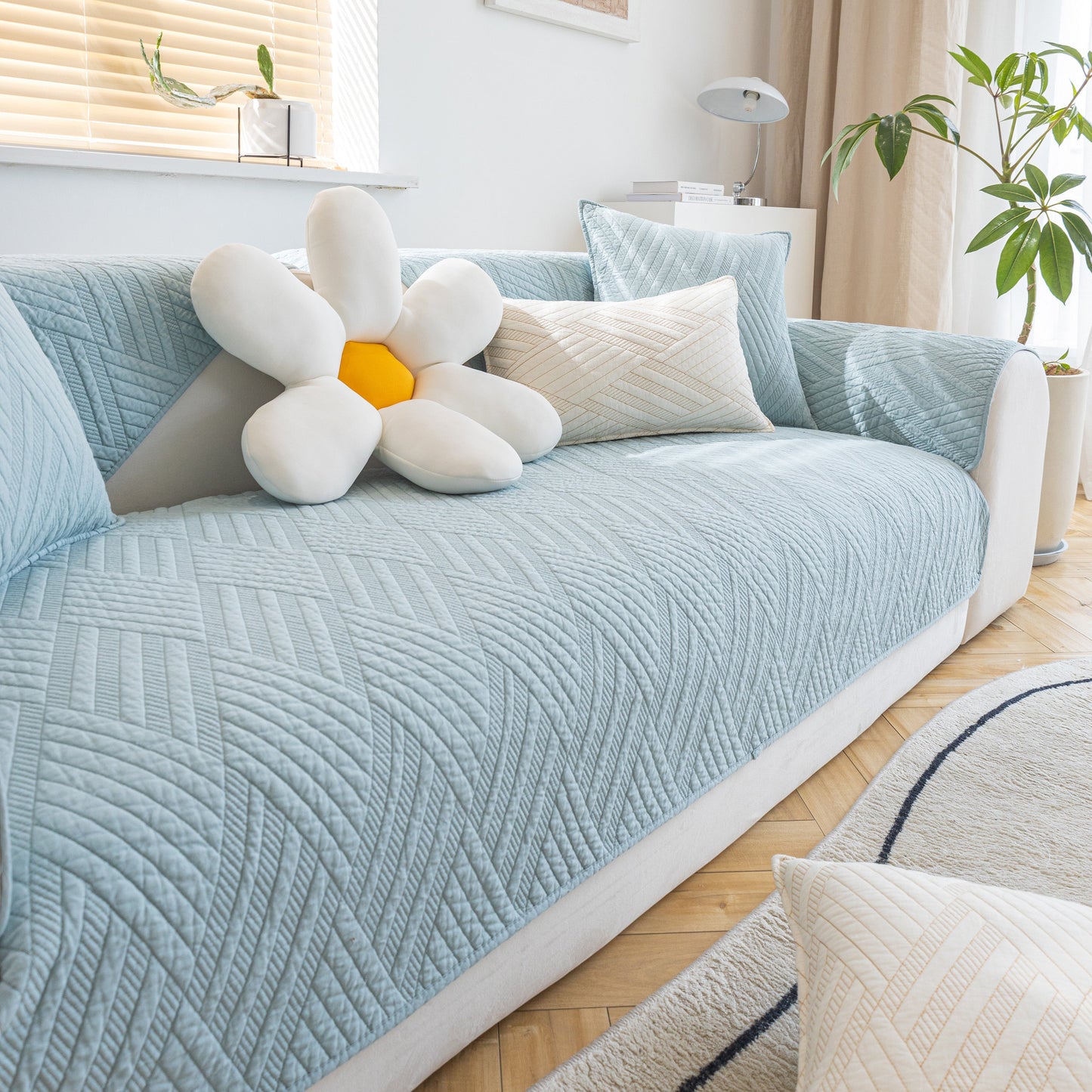 Quilted Geometric Cotton Sofa Cover, Non-Slip & Thick Padded Furniture Covers on blue sofa in living room.