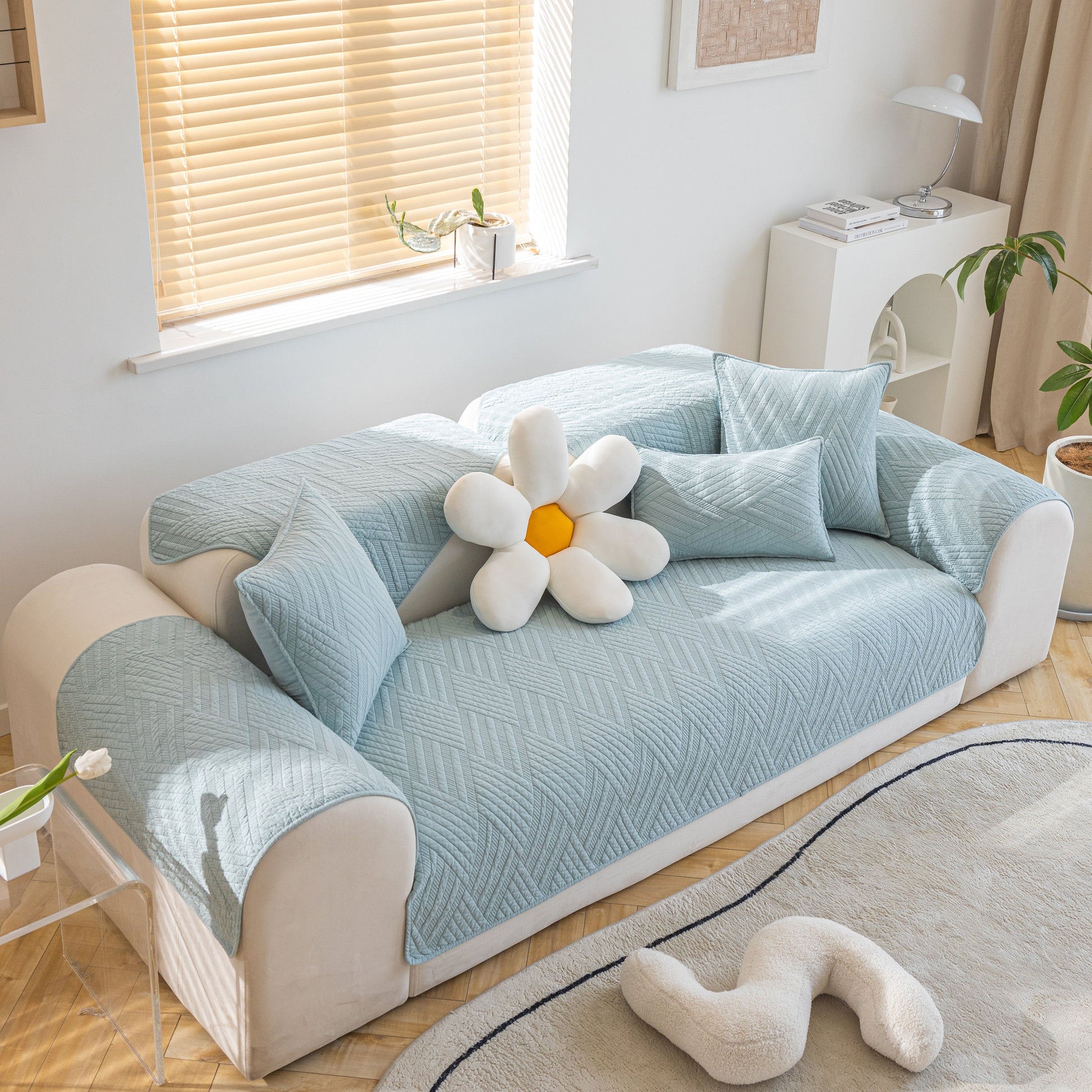 Light blue Quilted Geometric Cotton Sofa Cover on a couch, featuring non-slip thick padded furniture covers with decorative pillows.