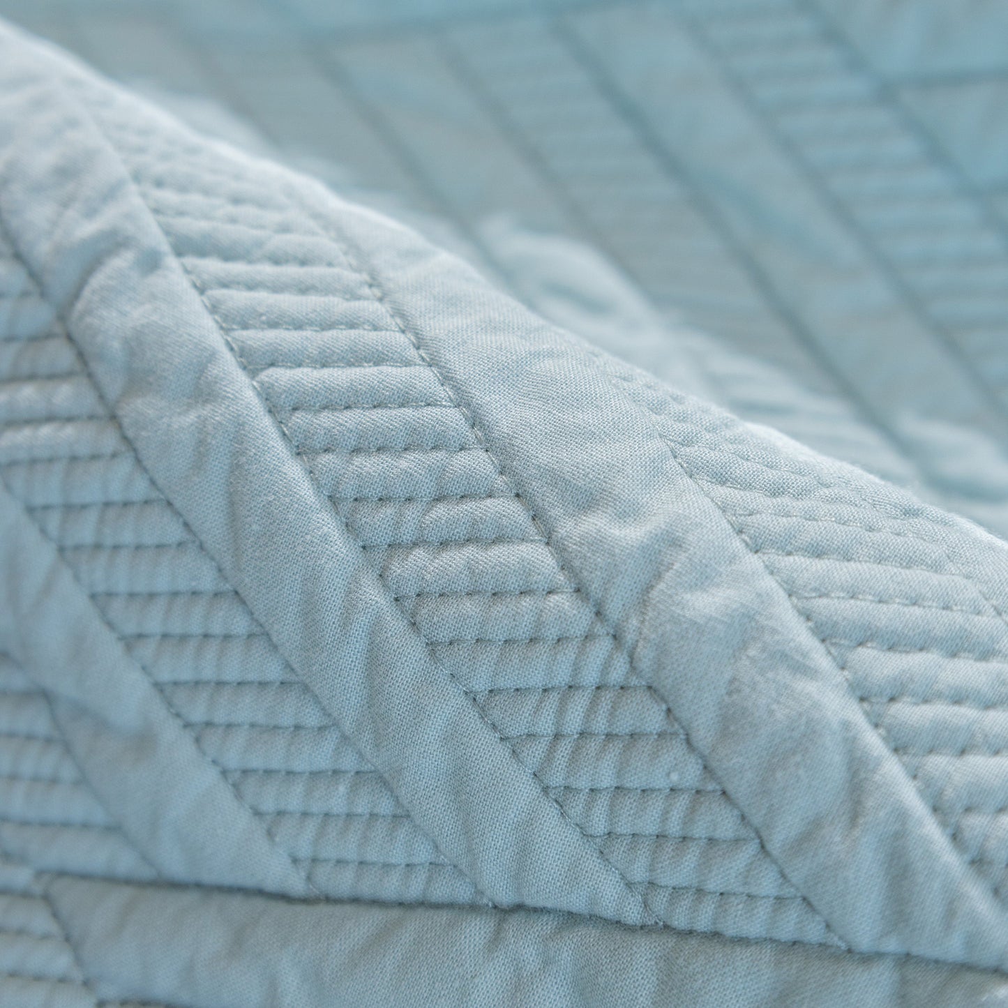 Close-up of Quilted Geometric Cotton Sofa Cover, Non-Slip & Thick Padded Furniture Covers with textured pattern.