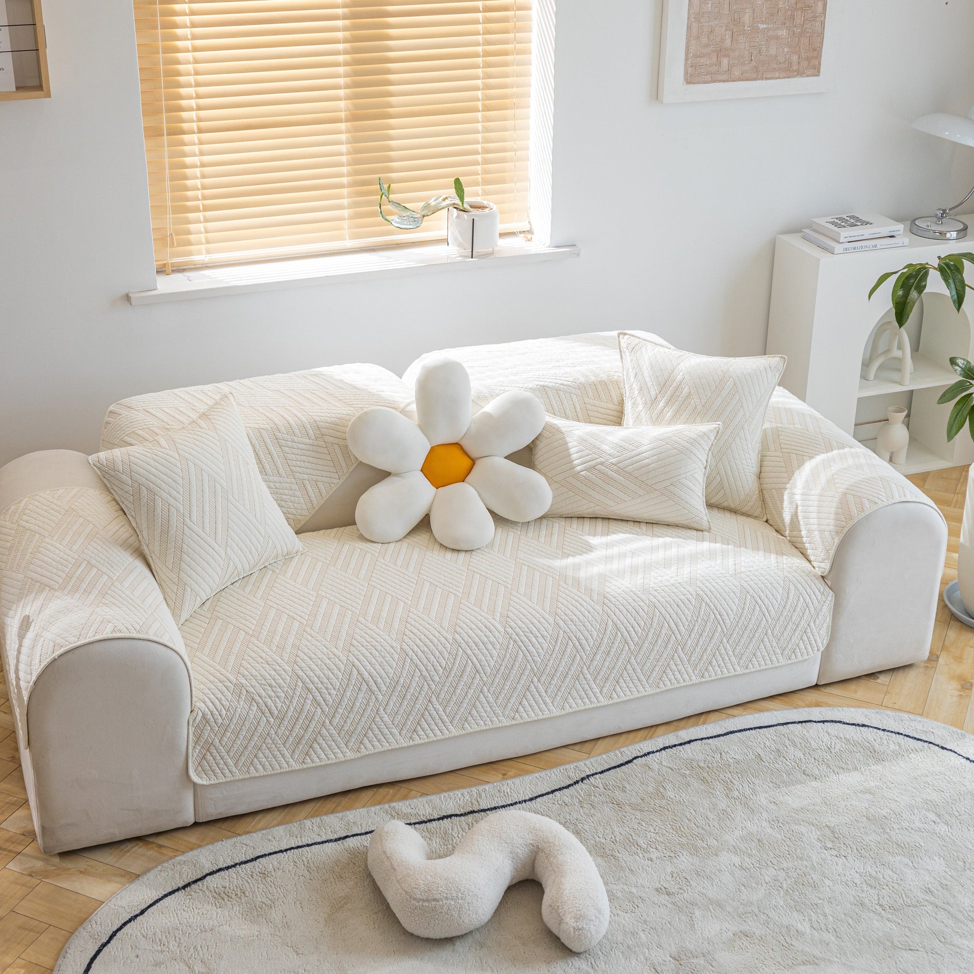 Living room with a sofa featuring a Quilted Geometric Cotton Sofa Cover, Non-Slip & Thick Padded Furniture Covers, decorated with cushions.