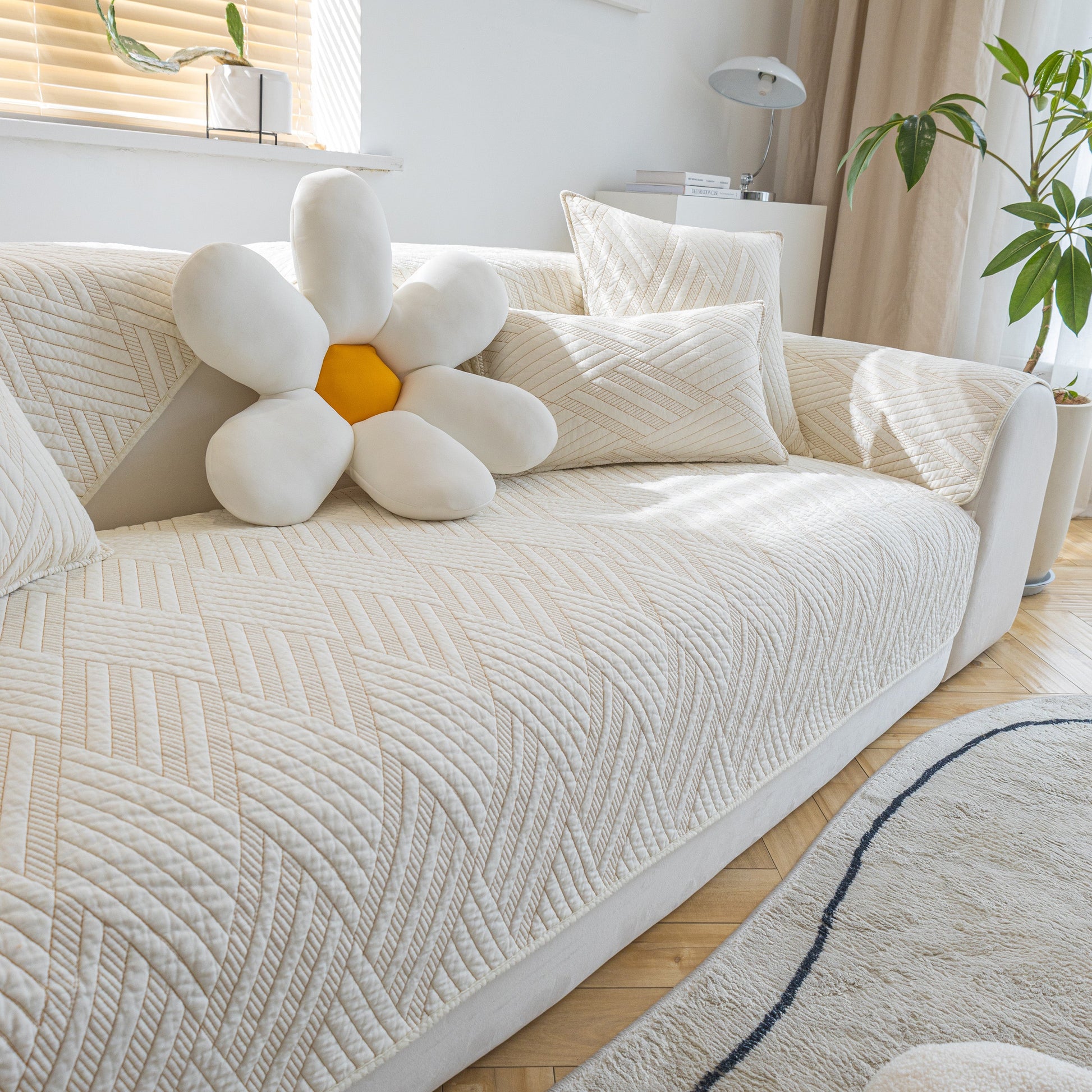 Quilted Geometric Cotton Sofa Cover, Non-Slip & Thick Padded Furniture Covers on a modern white sofa with decorative pillows.