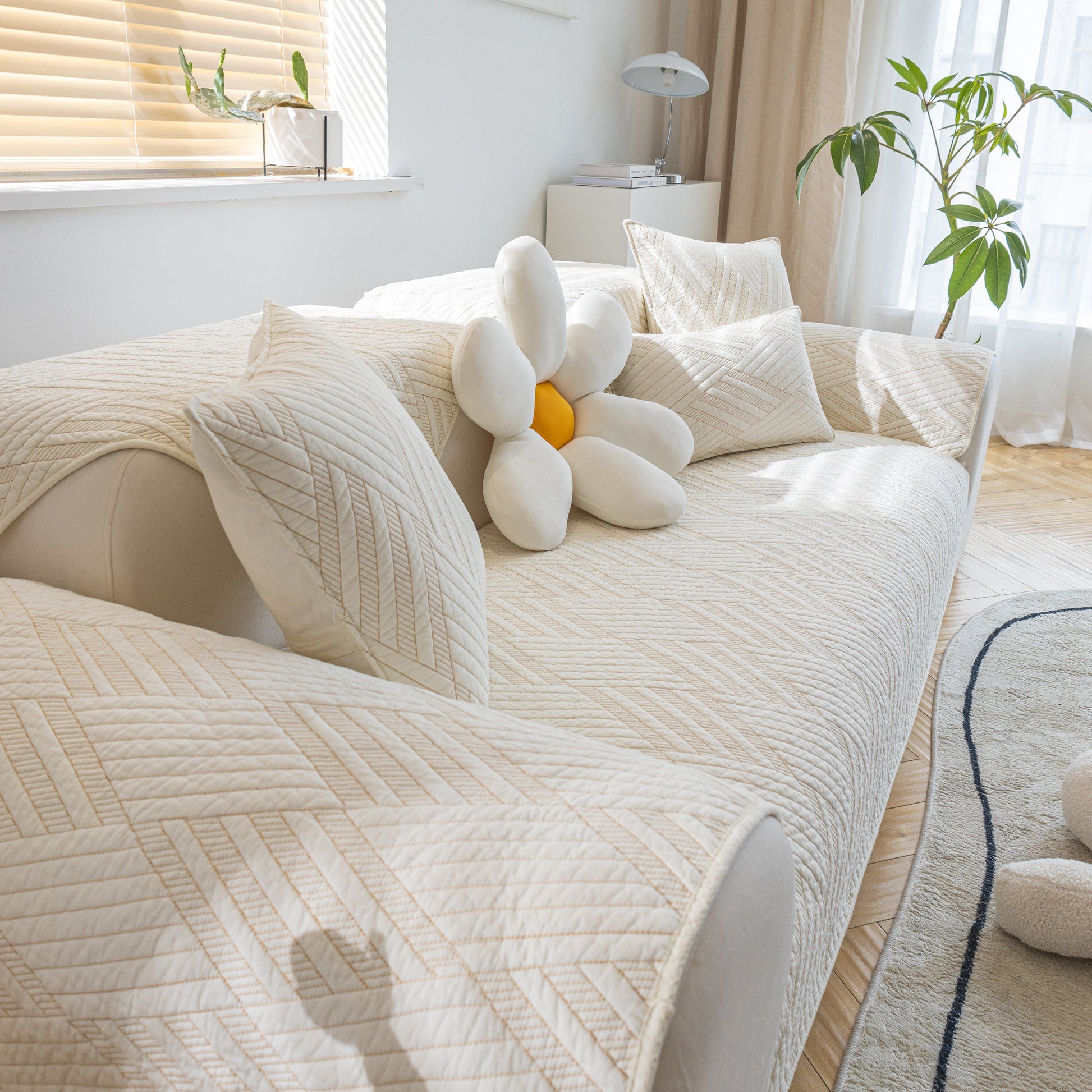 Quilted Geometric Cotton Sofa Cover, Non-Slip & Thick Padded Furniture Covers on contemporary sofa with pillows in sunlit room.