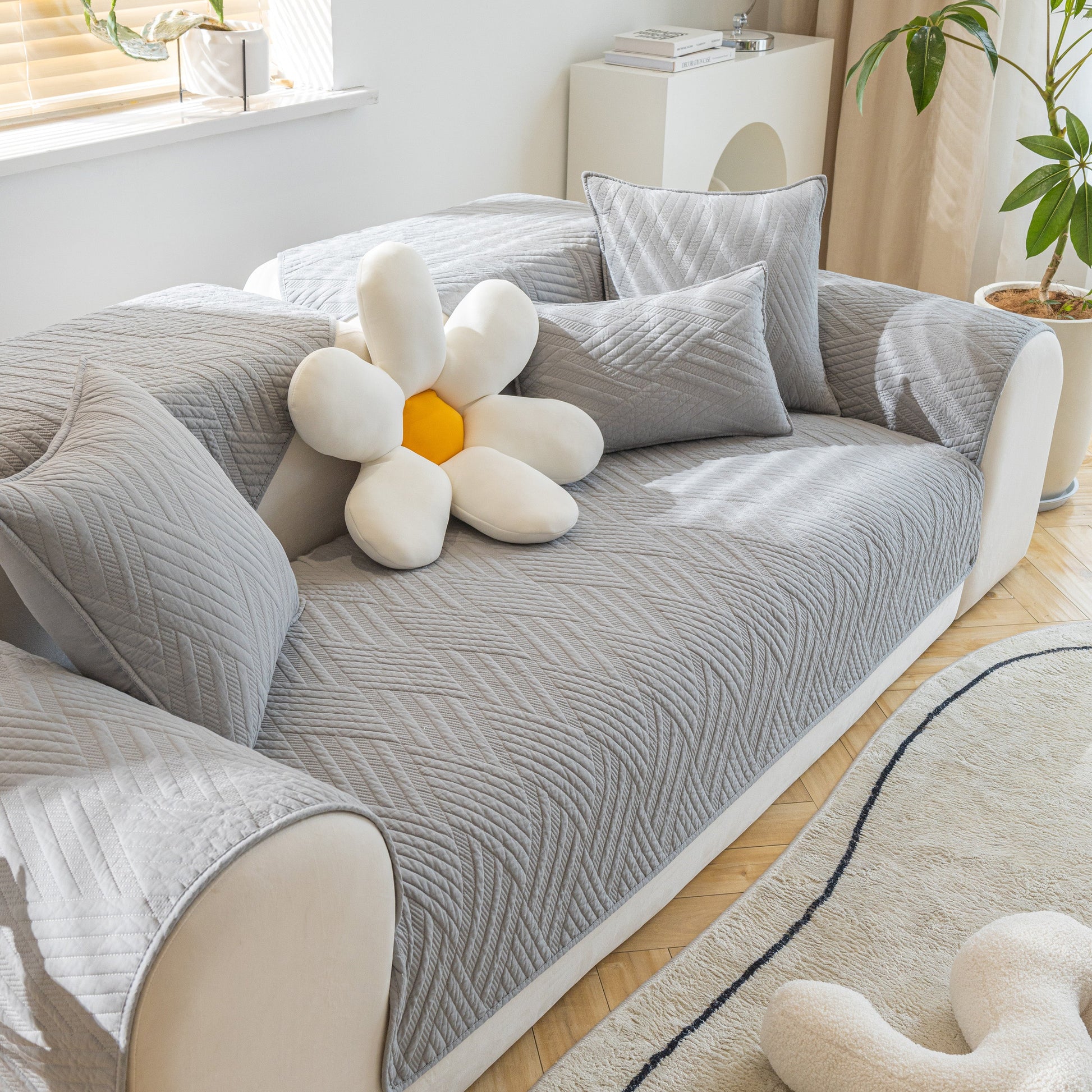 Quilted Geometric Cotton Sofa Cover, Non-Slip & Thick Padded Furniture Covers in gray on a modern sofa with decorative pillows.