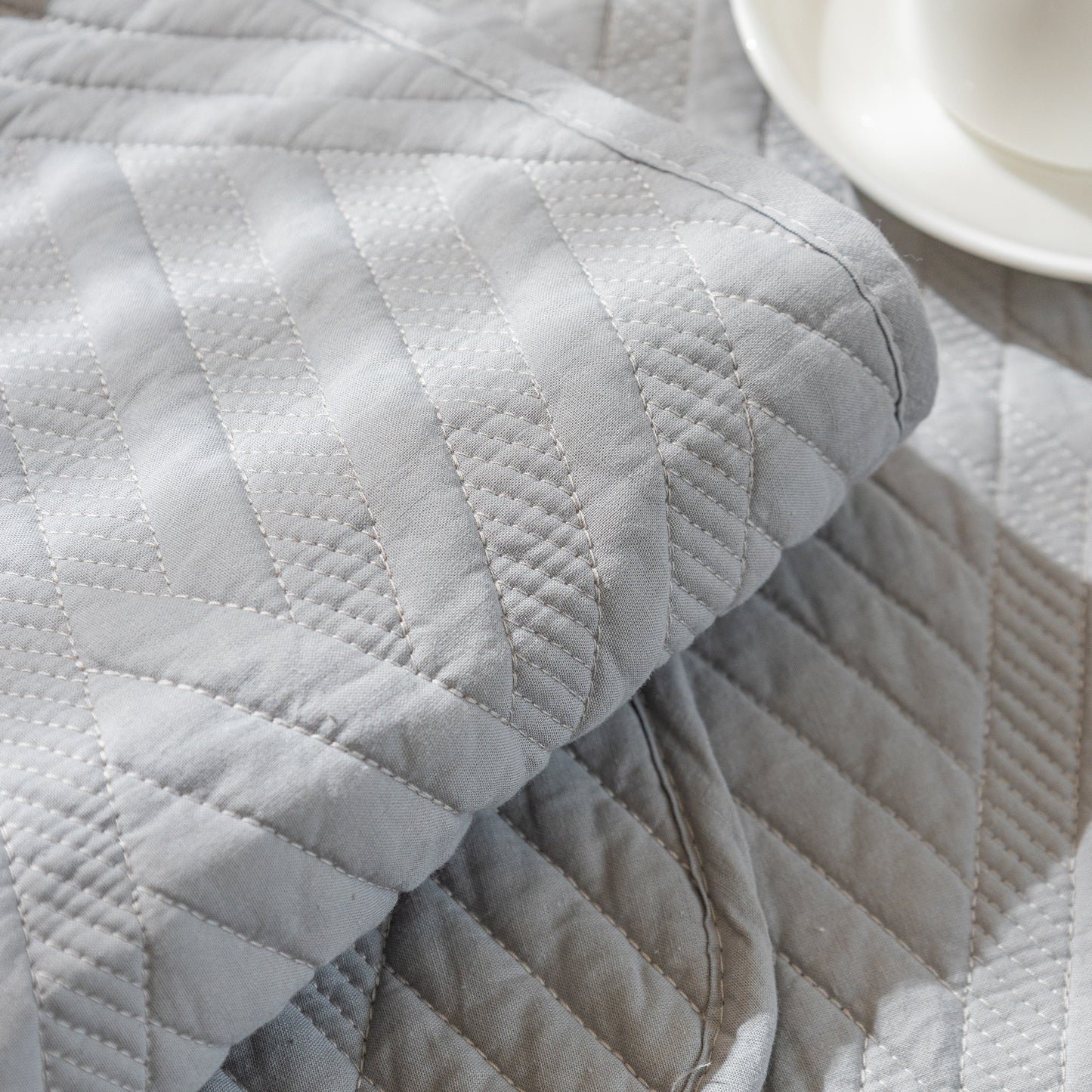 Close-up of Quilted Geometric Cotton Sofa Cover with non-slip and thick padded texture.