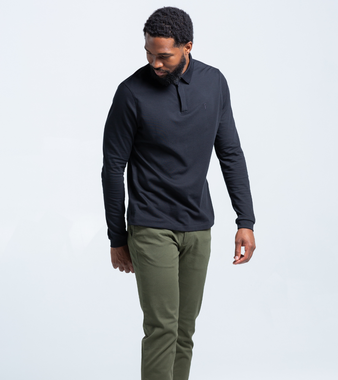 Man wearing black Long Sleeve Perfect Polo with StaySharp Collar, tailored fit, and green pants, exemplifying modern style and innovation.