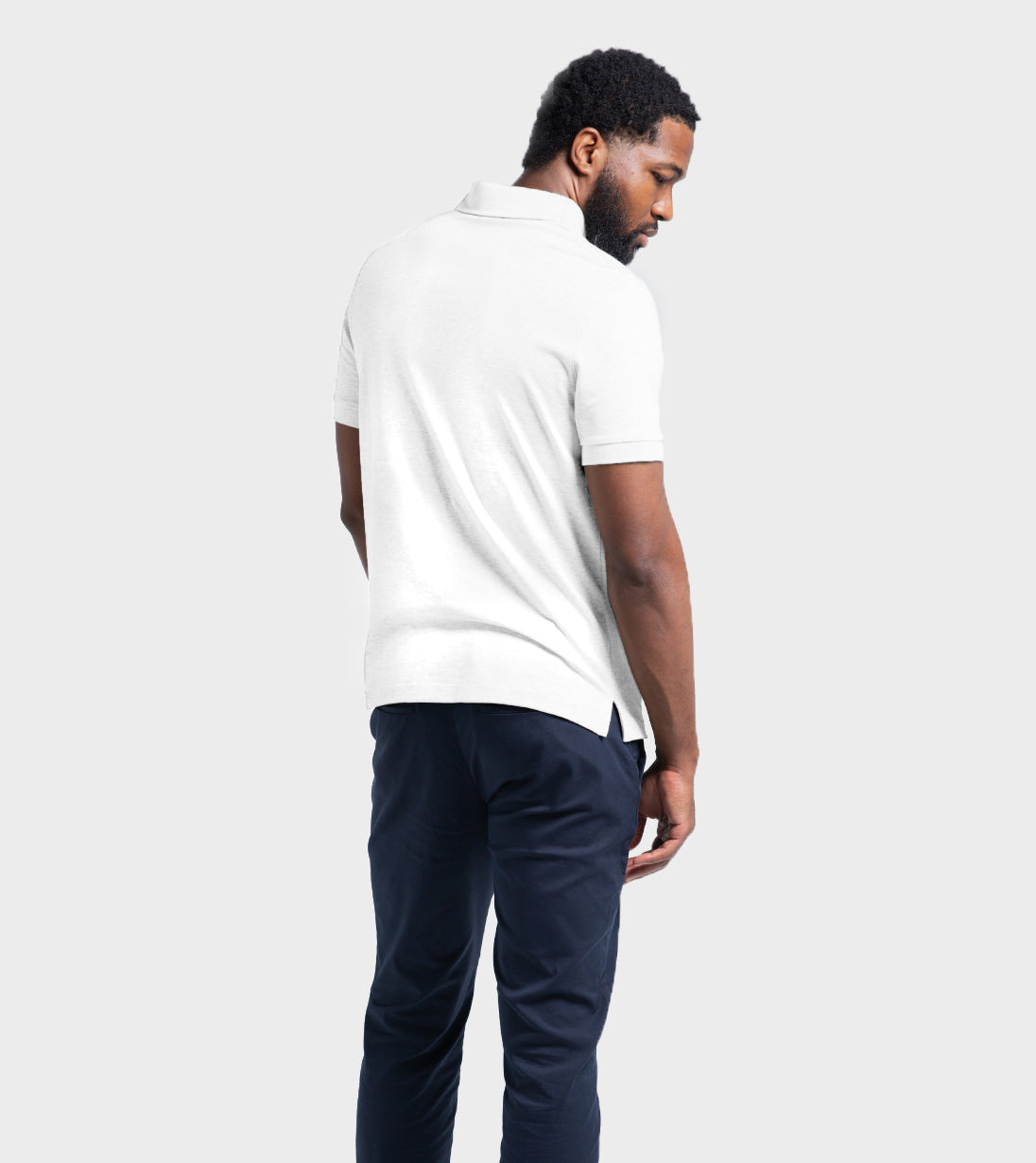 Back view of a man wearing the Baobab Short Sleeve Perfect Polo in white, showcasing a modern fit with tailored comfort and StaySharp™ Collar.