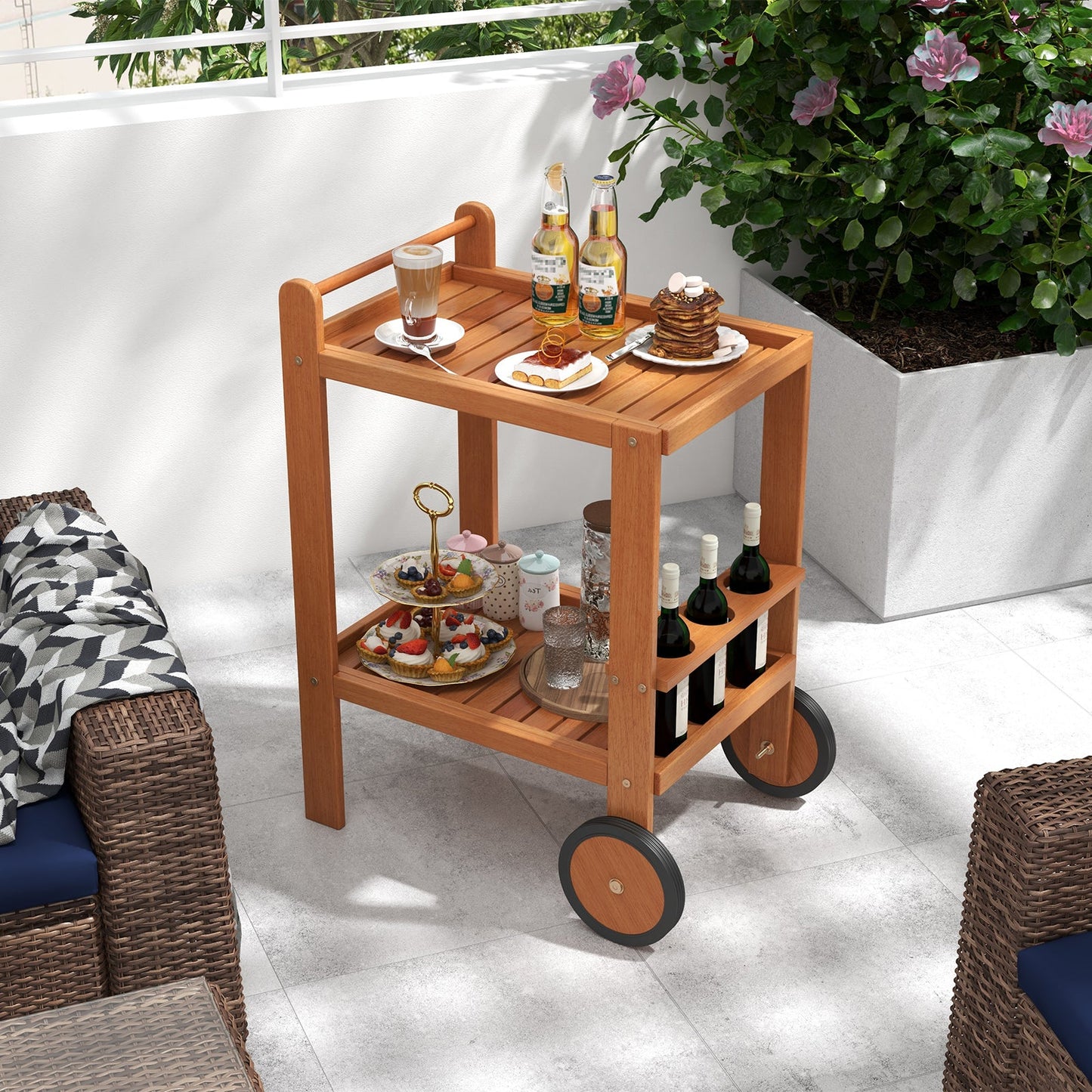 2 Tier Rolling Serving Cart with Wine Bottle Holders and 2 Rubber Wheels on a patio, displaying drinks and appetizers.