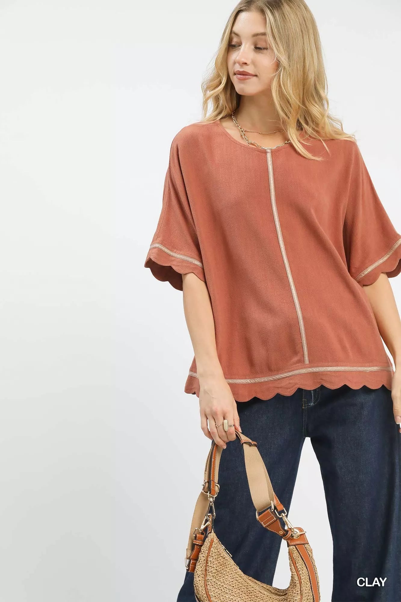 Woman wearing Umgee Linen Blend Scallop Trim Top in clay, casual chic style with scalloped edges and round neckline for versatile wear.