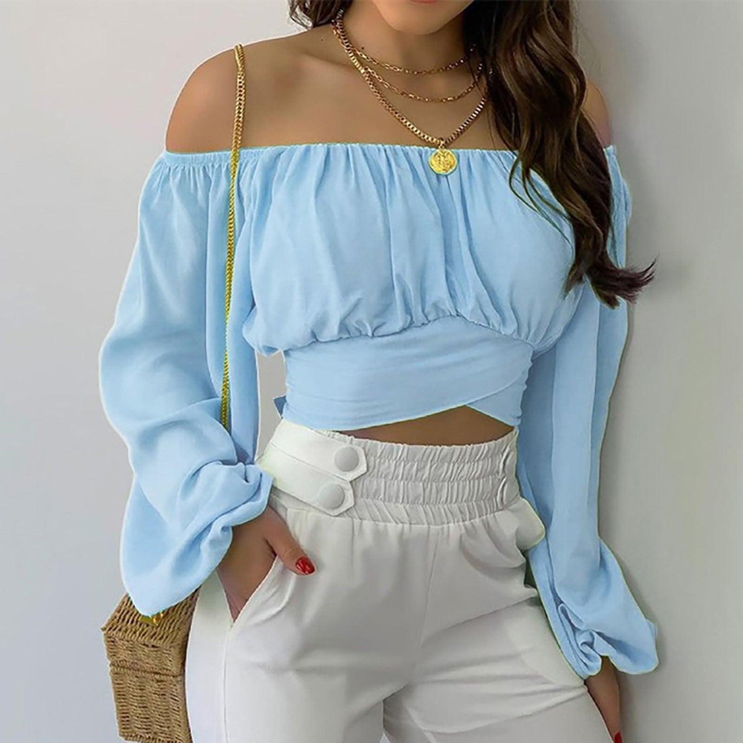 Woman wearing Off Shoulder Cross Tie Long Sleeve Top | Sexy & Trendy Cowgirl Look in light blue with white pants and gold jewelry.