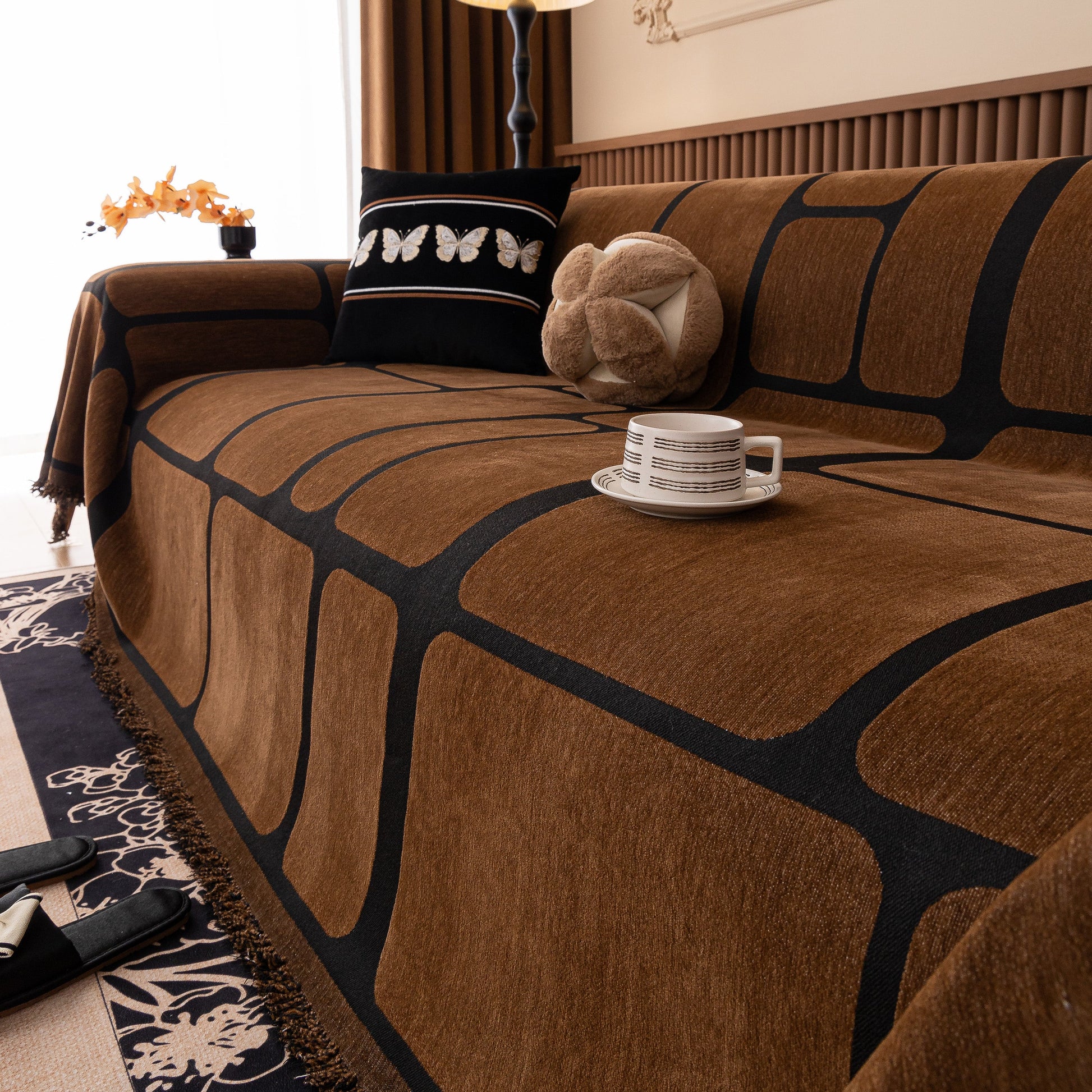 Modern Geometric Sofa Cover Decorative Couch Throw Blanket Furniture Protector on a brown couch with tassel edges.