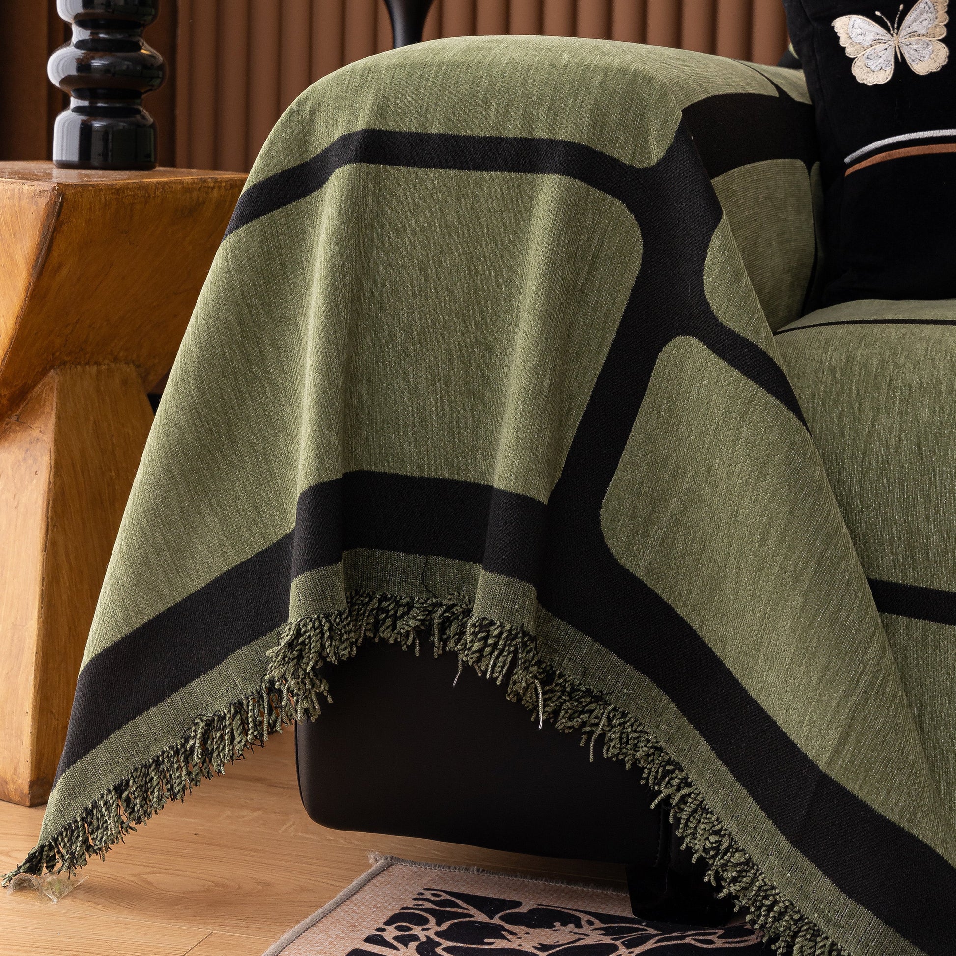 Modern Geometric Sofa Cover Decorative Couch Throw Blanket Furniture Protector in green with tassel edges draped over a sofa.