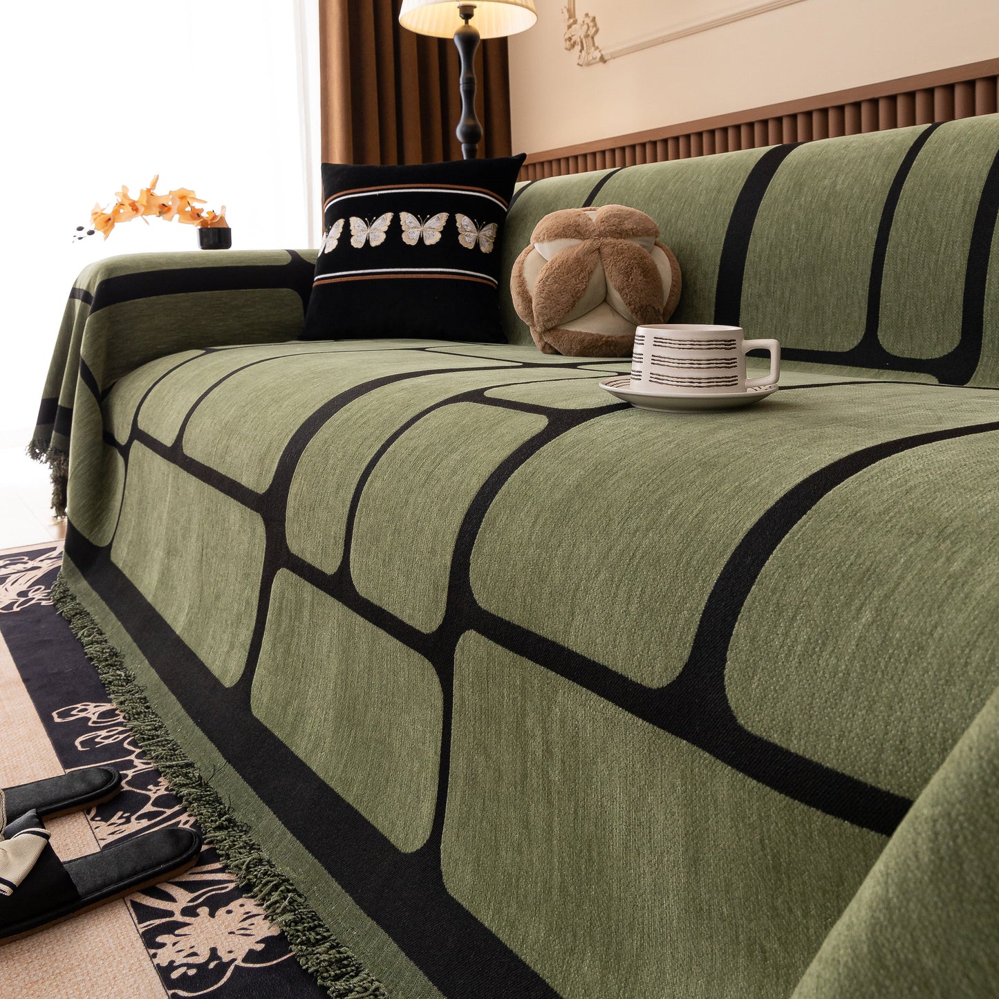 Modern Geometric Sofa Cover Decorative Couch Throw Blanket Furniture Protector in green with tassel edges on a stylish sofa.