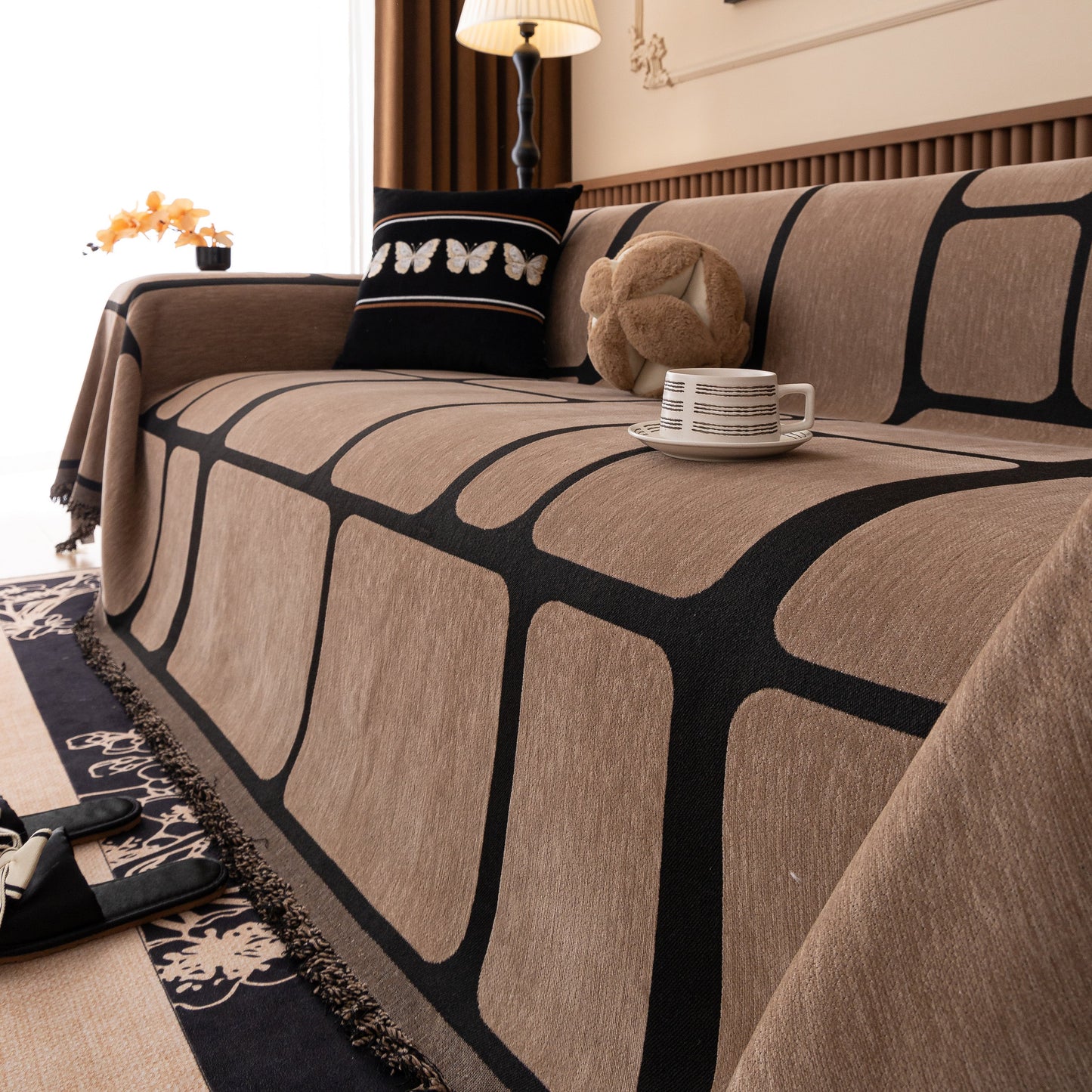 Modern Geometric Sofa Cover Decorative Couch Throw Blanket Furniture Protector in brown with tassel edges on a living room sofa.