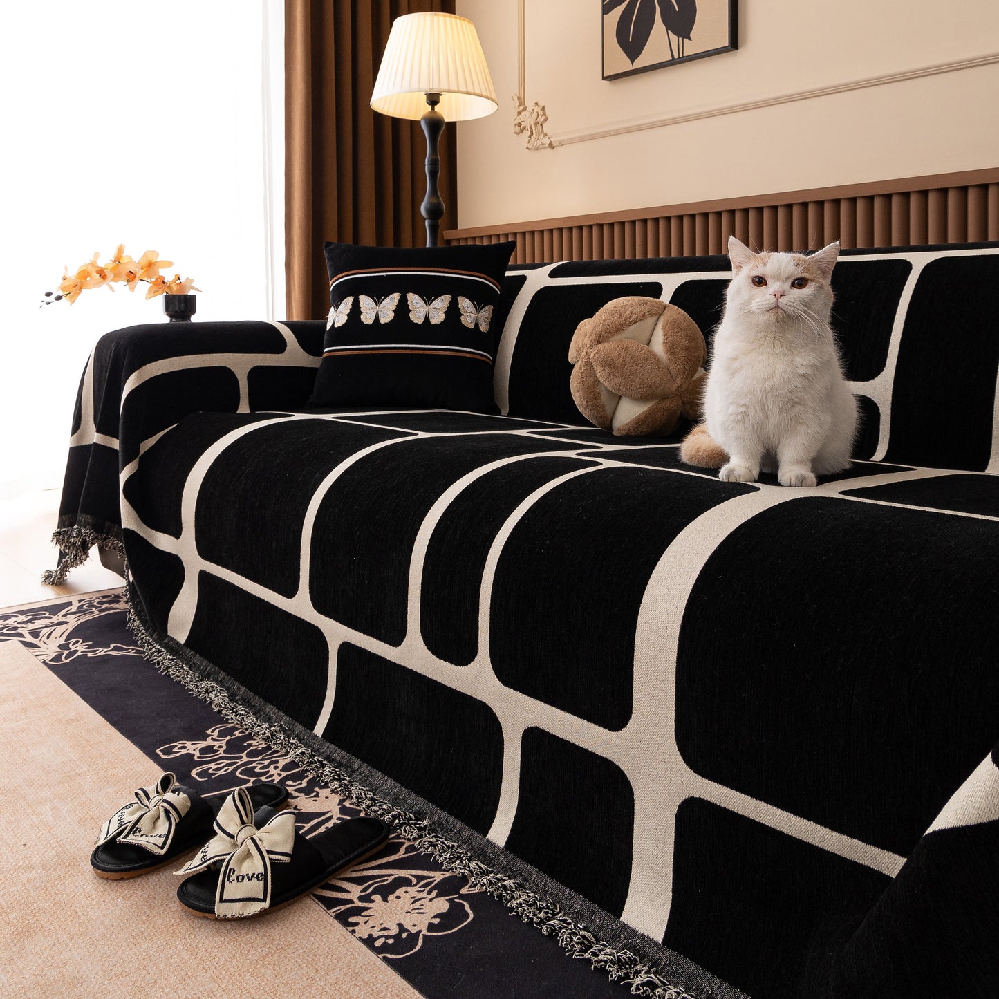 Modern Geometric Sofa Cover Decorative Couch Throw Blanket Furniture Protector in black and white with tassel edges on a sofa.