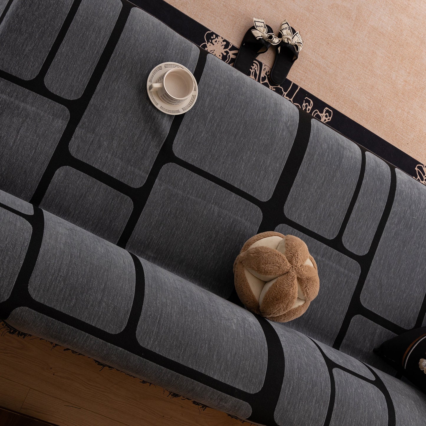 Modern Geometric Sofa Cover Decorative Couch Throw Blanket Furniture Protector in black and gray with tassel edges on a sofa