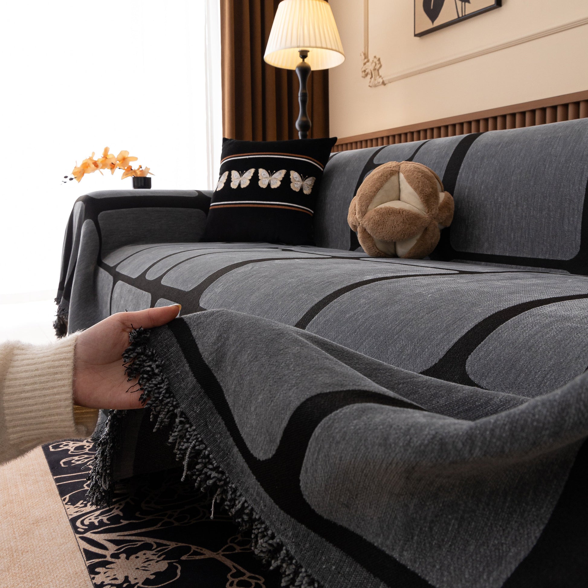 Modern Geometric Sofa Cover Decorative Couch Throw Blanket Furniture Protector with geometric pattern and tassel edges on a couch