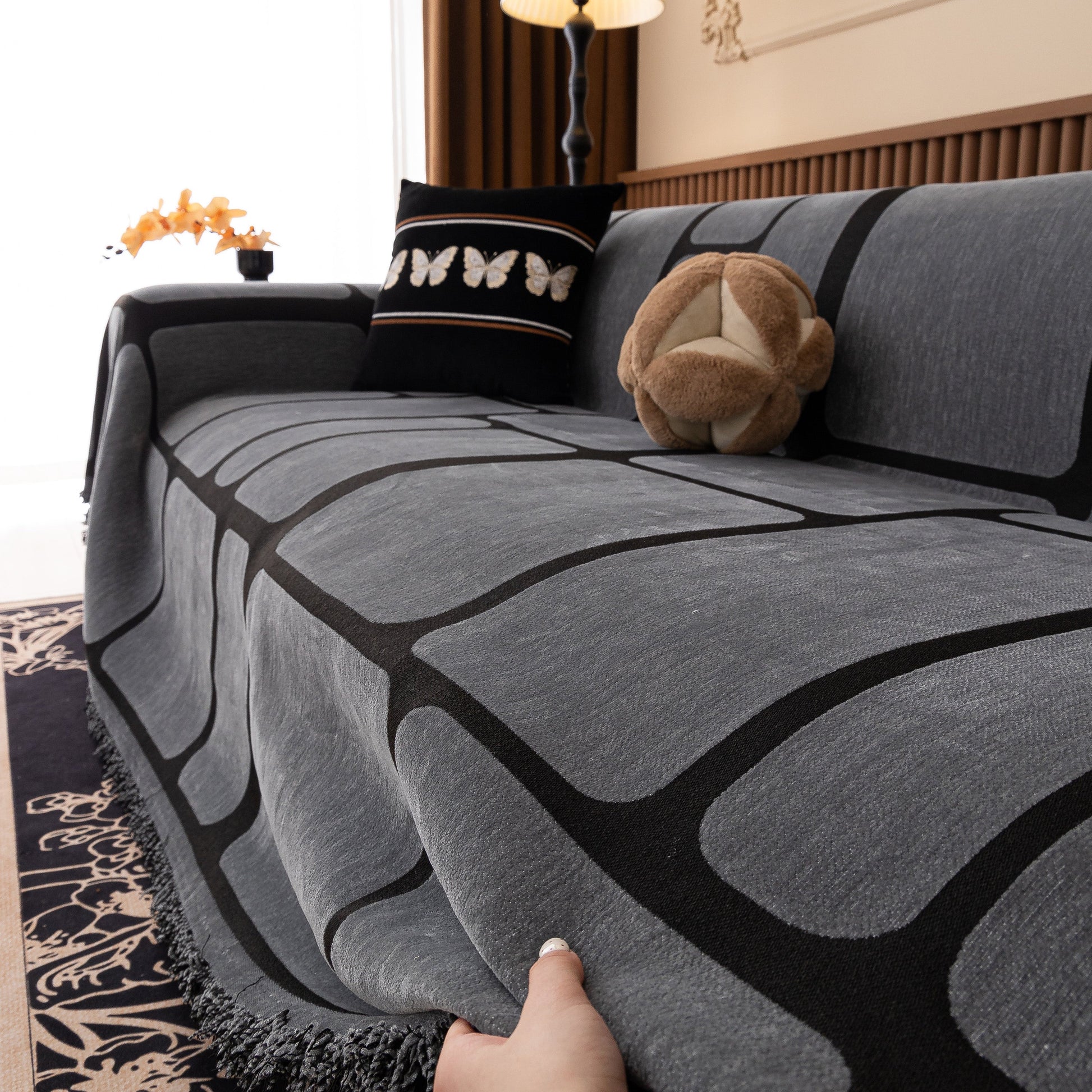 Modern Geometric Sofa Cover Decorative Couch Throw Blanket Furniture Protector in geometric pattern with tassel edges on a couch.
