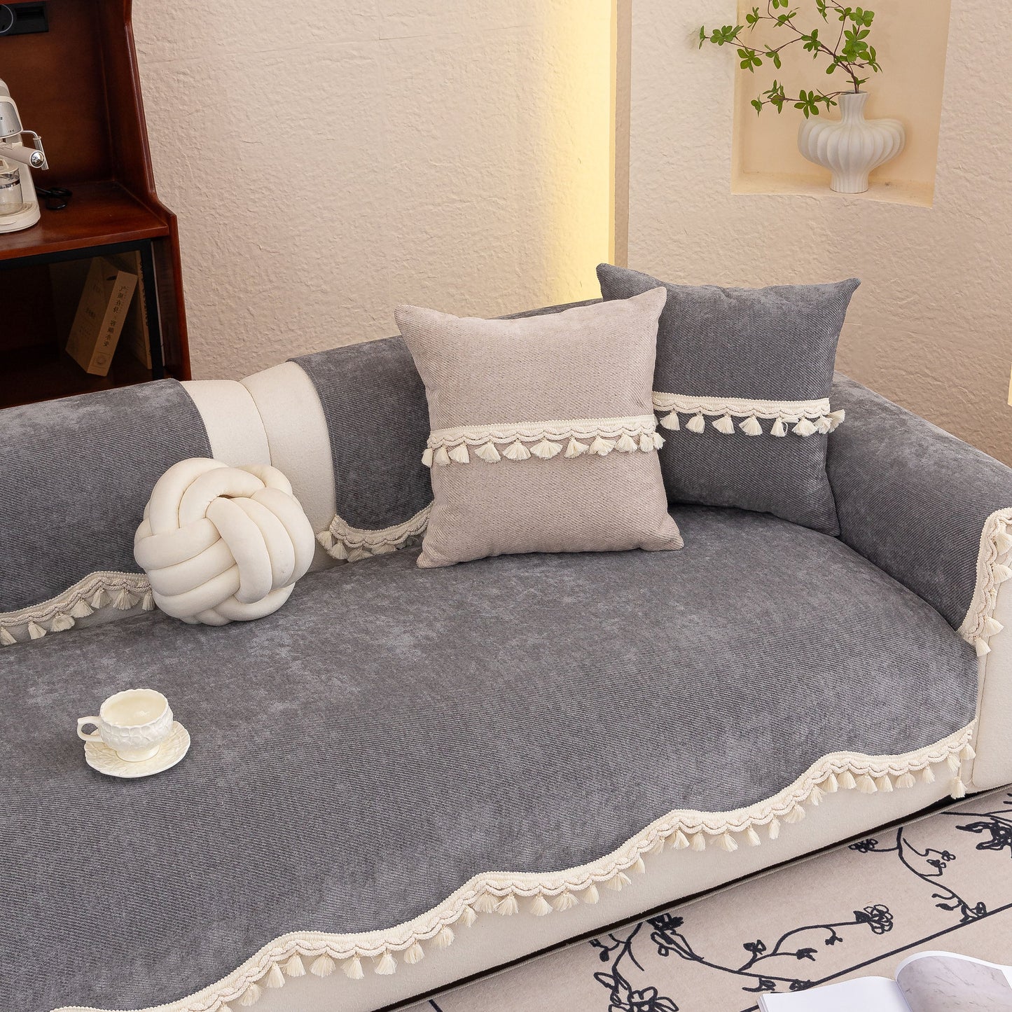 Chenille Sofa Cover Towel – Non-Slip, Washable Pets Couch Protector with Tassels on a grey sofa with decorative pillows and a knot pillow.