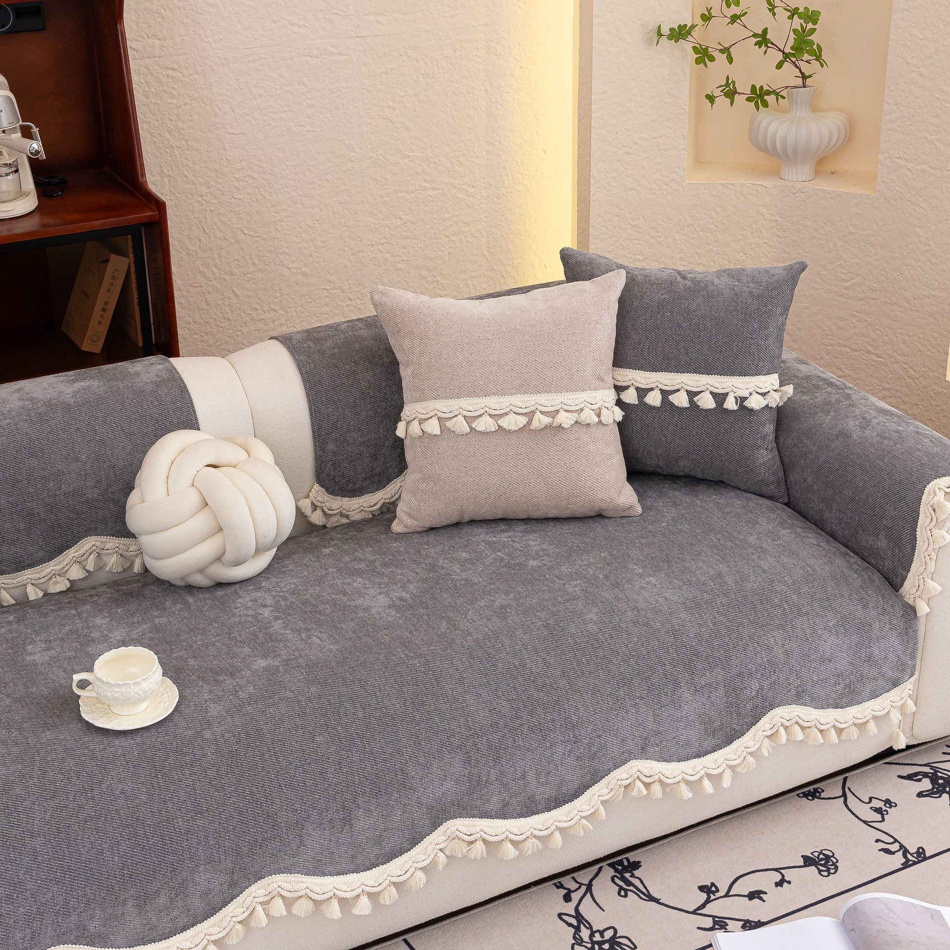 Chenille Sofa Cover Towel – Non-Slip, Washable Pets Couch Protector with Tassels on a grey sofa with decorative pillows and a knot pillow.