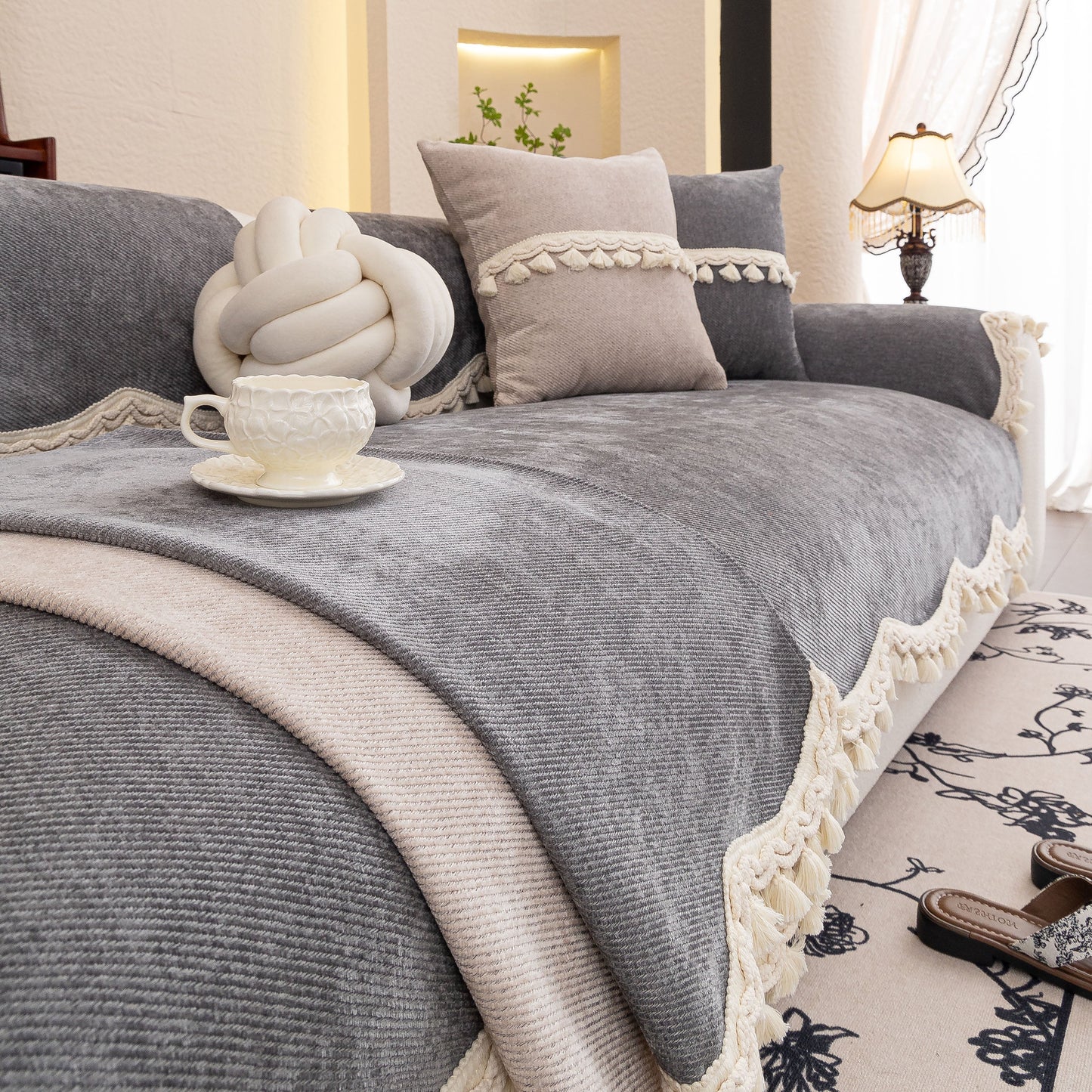Chenille Sofa Cover Towel – Non-Slip, Washable Pets Couch Protector with Tassels on a cozy grey sofa.