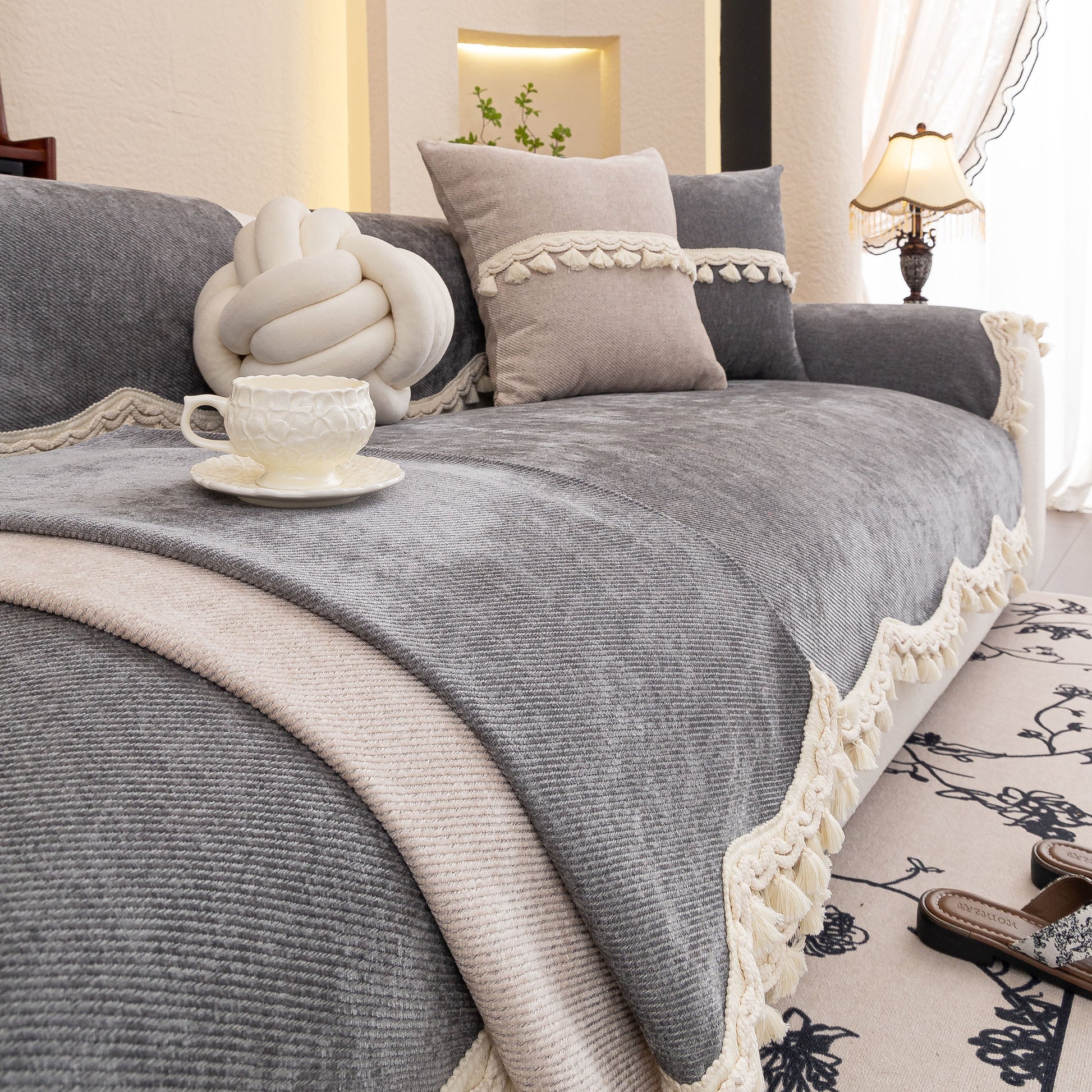 Chenille Sofa Cover Towel – Non-Slip, Washable Pets Couch Protector with Tassels on a cozy grey sofa.