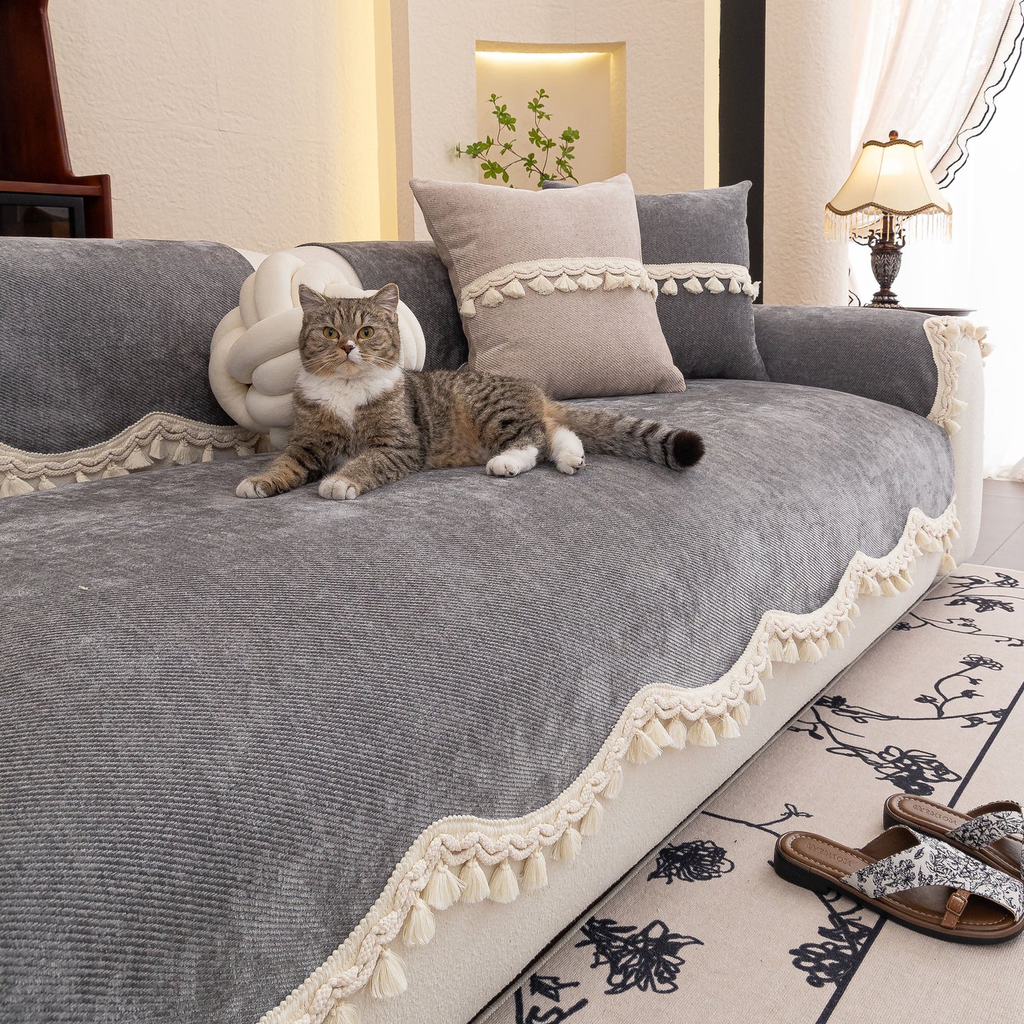Chenille Sofa Cover Towel – Non-Slip, Washable Pets Couch Protector with Tassels covering a sofa with a cat laying on top